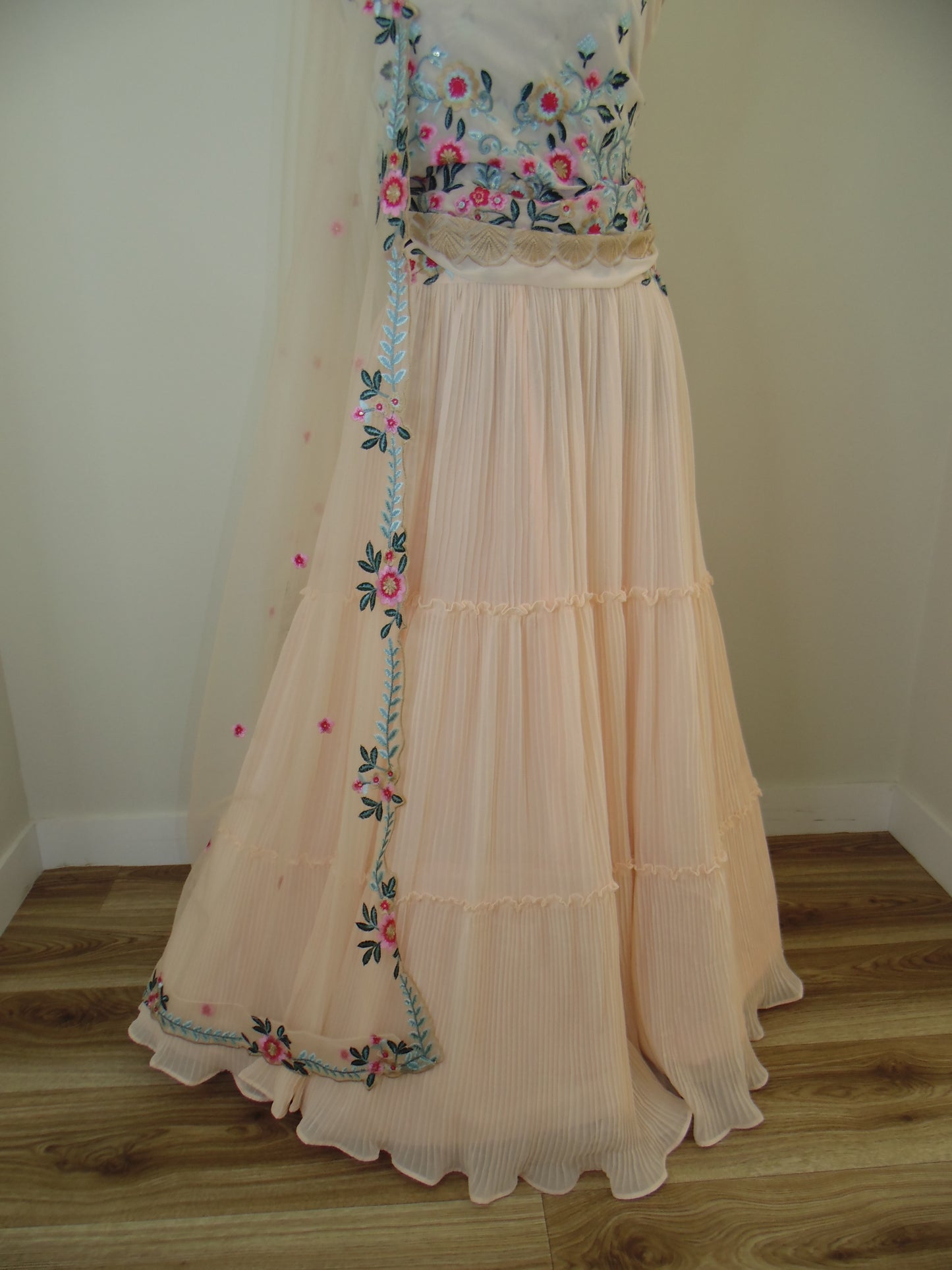 Beige curtains with floral embroidery on a wooden window frame.
