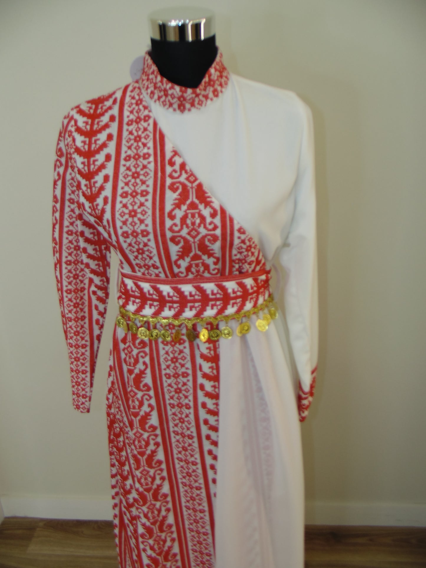 Traditional embroidered garment on a mannequin with a plain background