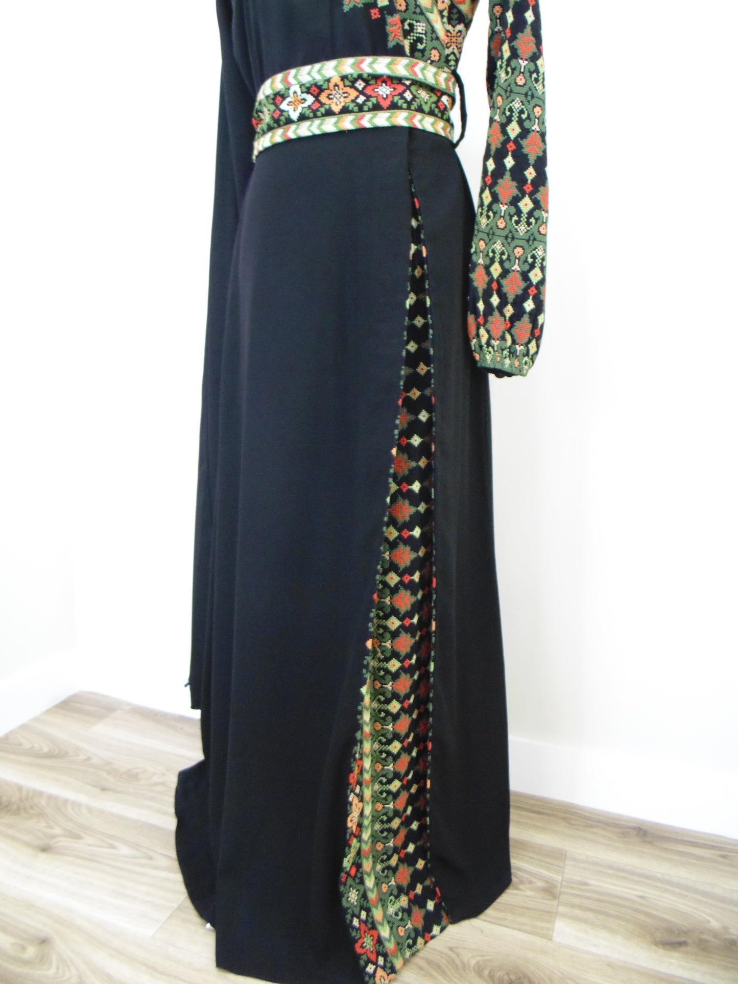 Black thobe with a colorful patterned belt on a white background