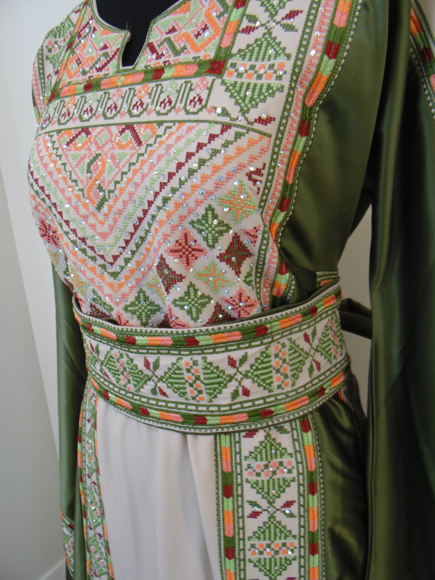 Embroidered fabric with geometric patterns on a green background