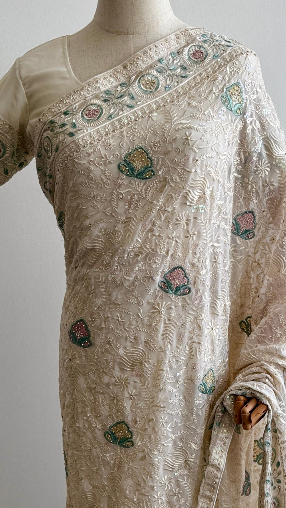 Saree with floral patterns on a mannequin against a white background