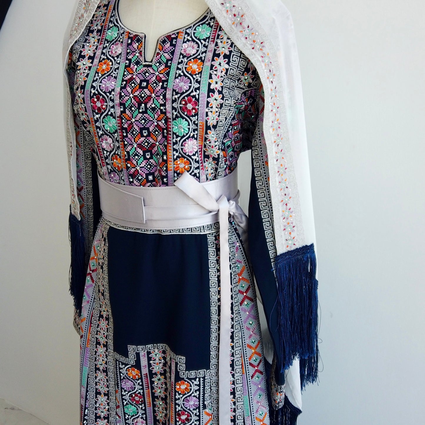 Close-up of Palestinian embroidery on traditional navy thobe