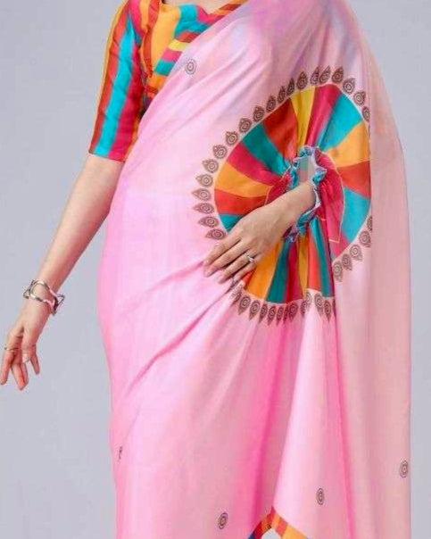 Woman wearing a pink saree with colorful patterns on a gray background