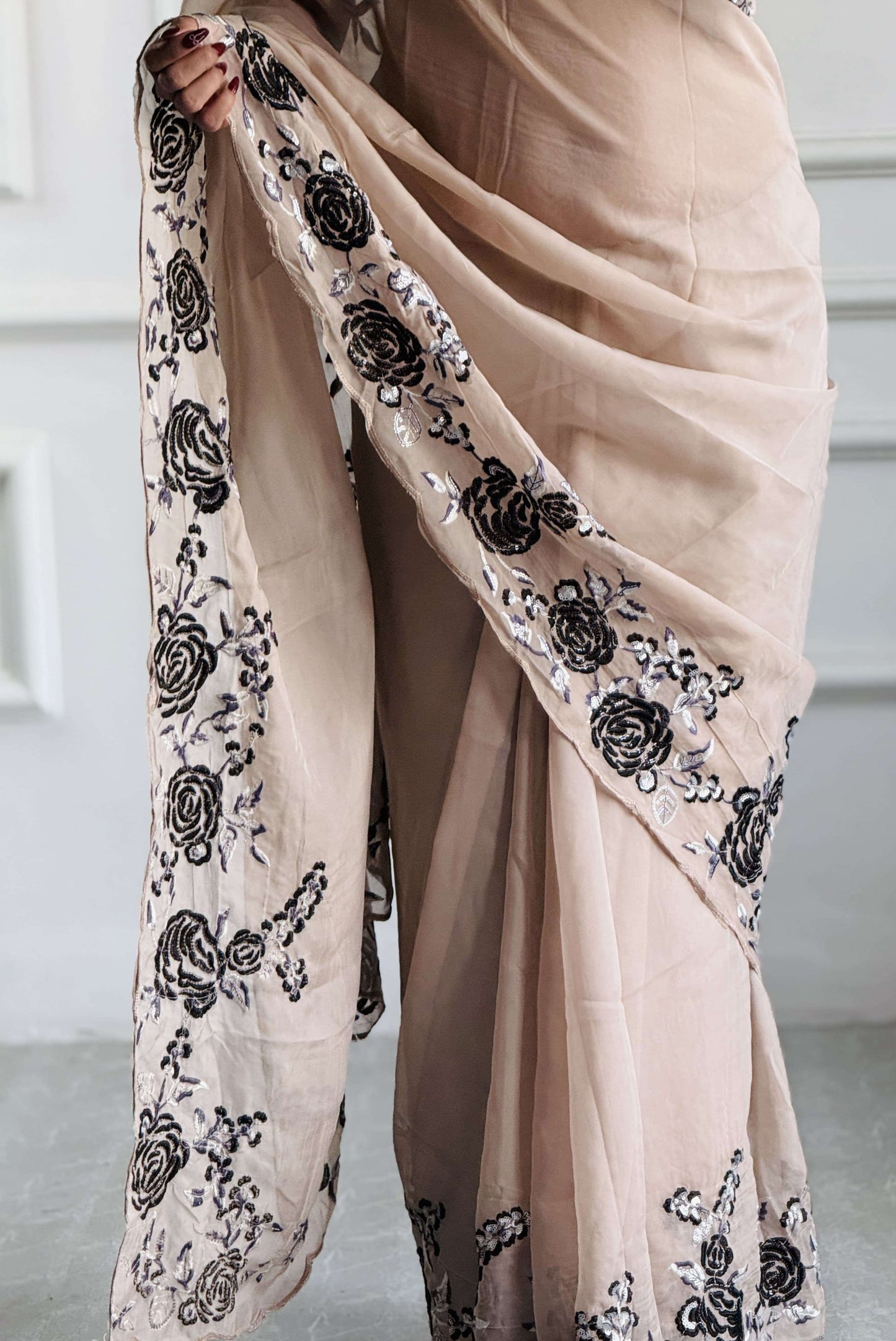 Detailed black thread embroidery on soft beige organza - handcrafted patterns showcasing refined artistry and heritage-inspired design