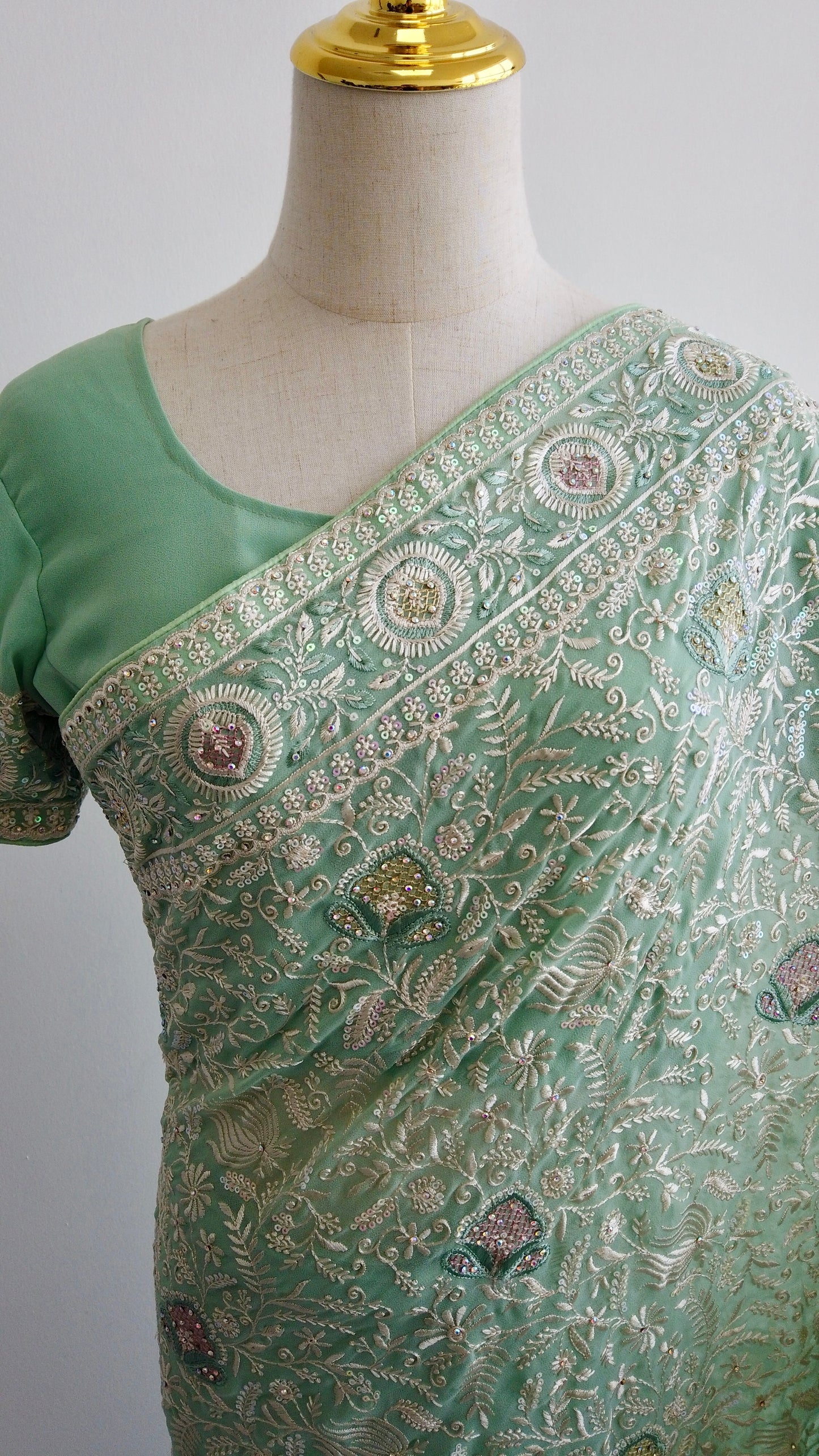 Close-up of green thread embroidery on georgette