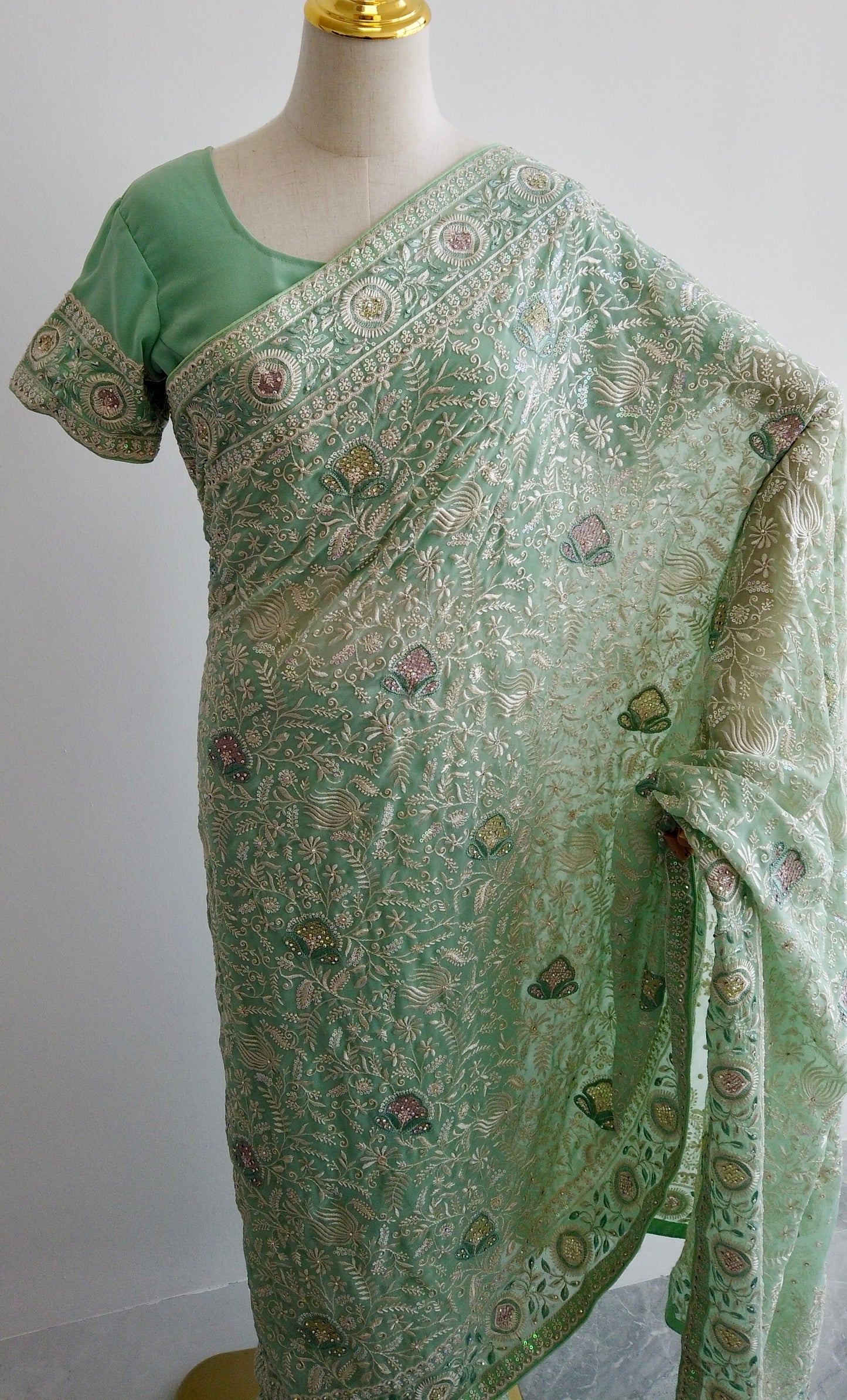 Full view of green saree showing pre-stitched pleats