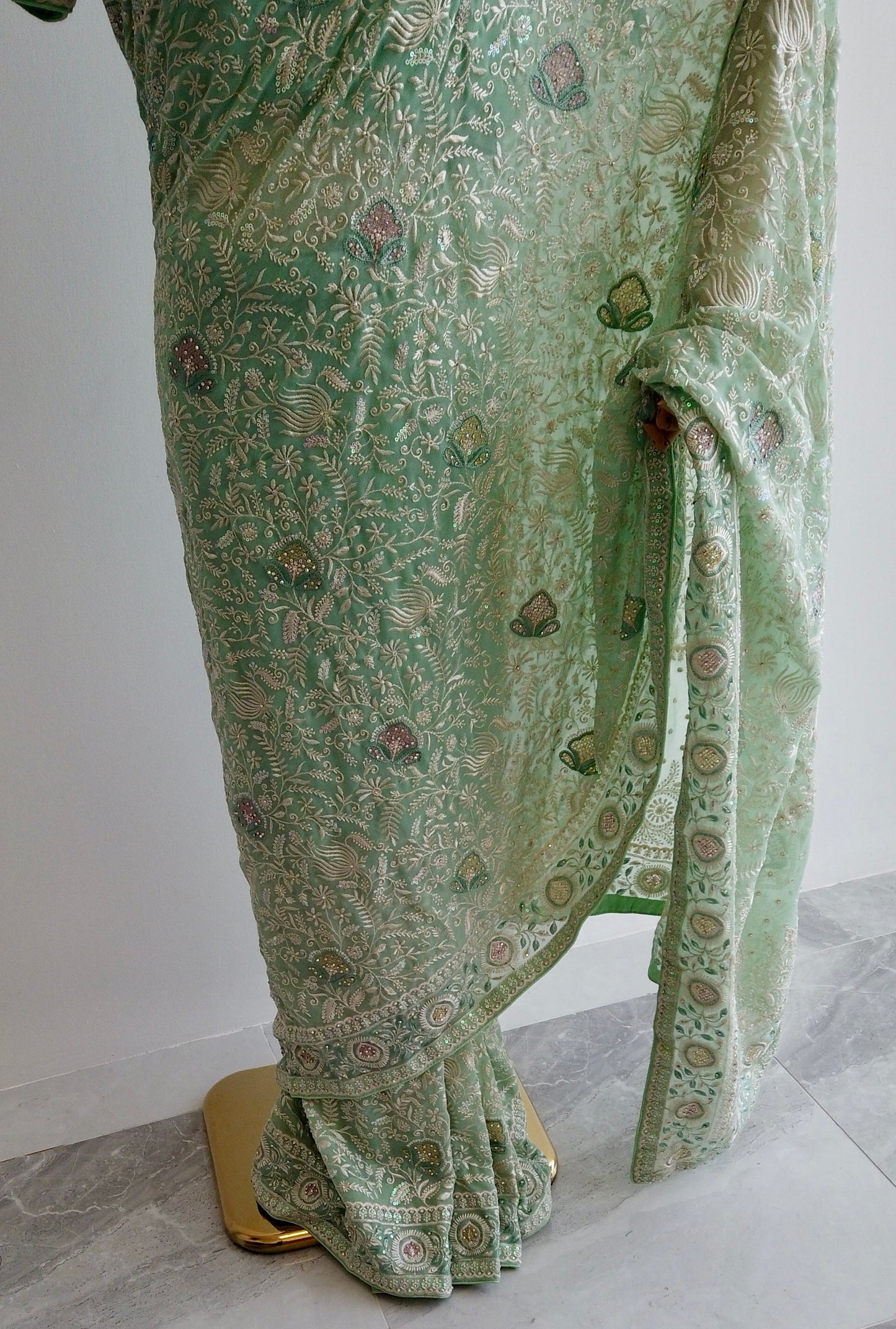 Green patterned fabric on a mannequin against a white background