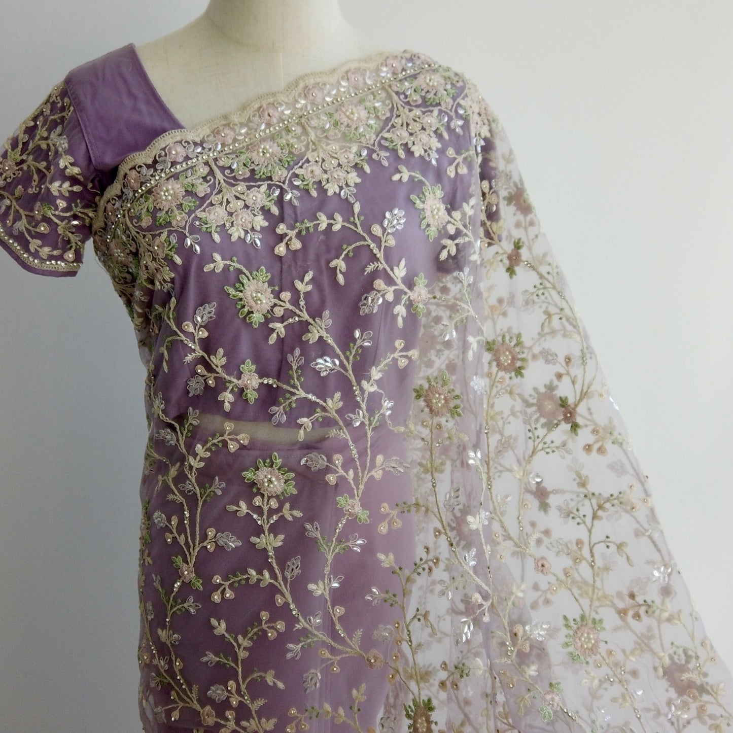 Purple net ready-to-wear saree with gold floral embroidery displayed on a mannequin