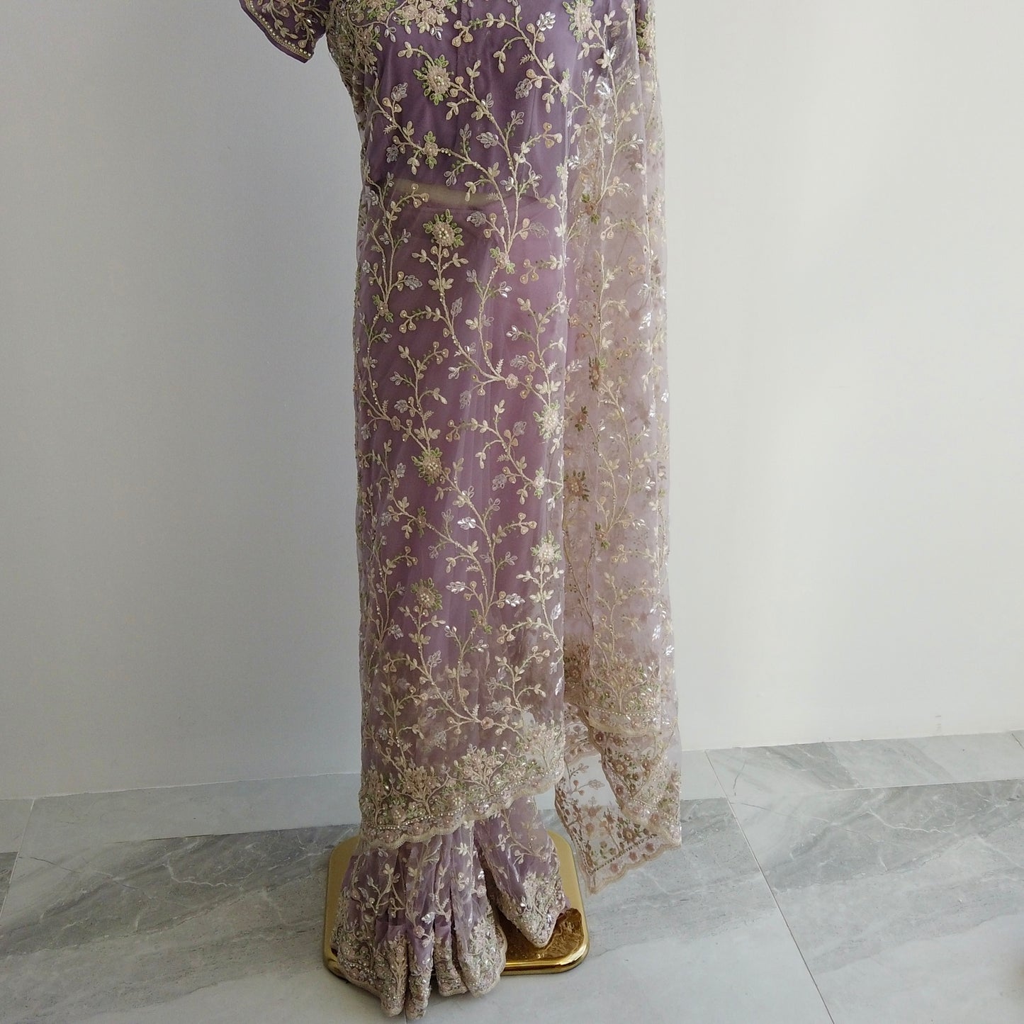 Full-length view of purple embroidered saree showing pre-stitched pleats and elegant pallu.