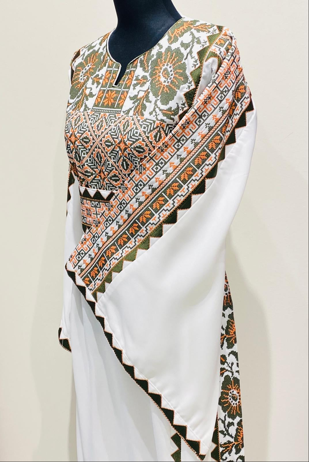 Ivory Palestinian-inspired thobe with geometric and floral embroidery at Arisca Qatar.
