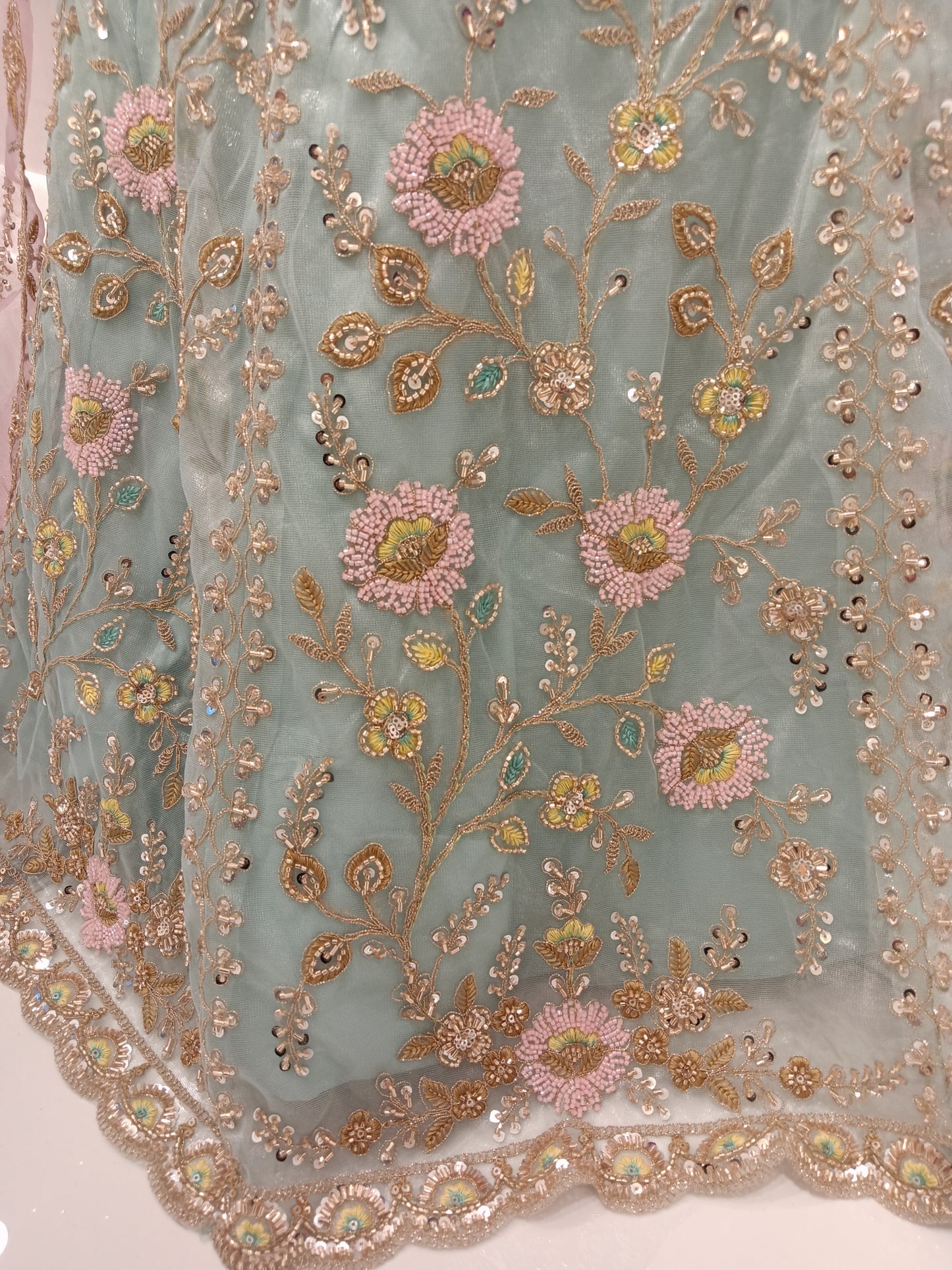 Lehenga Skirt: Net with pastel floral embroidery and sequin highlights.