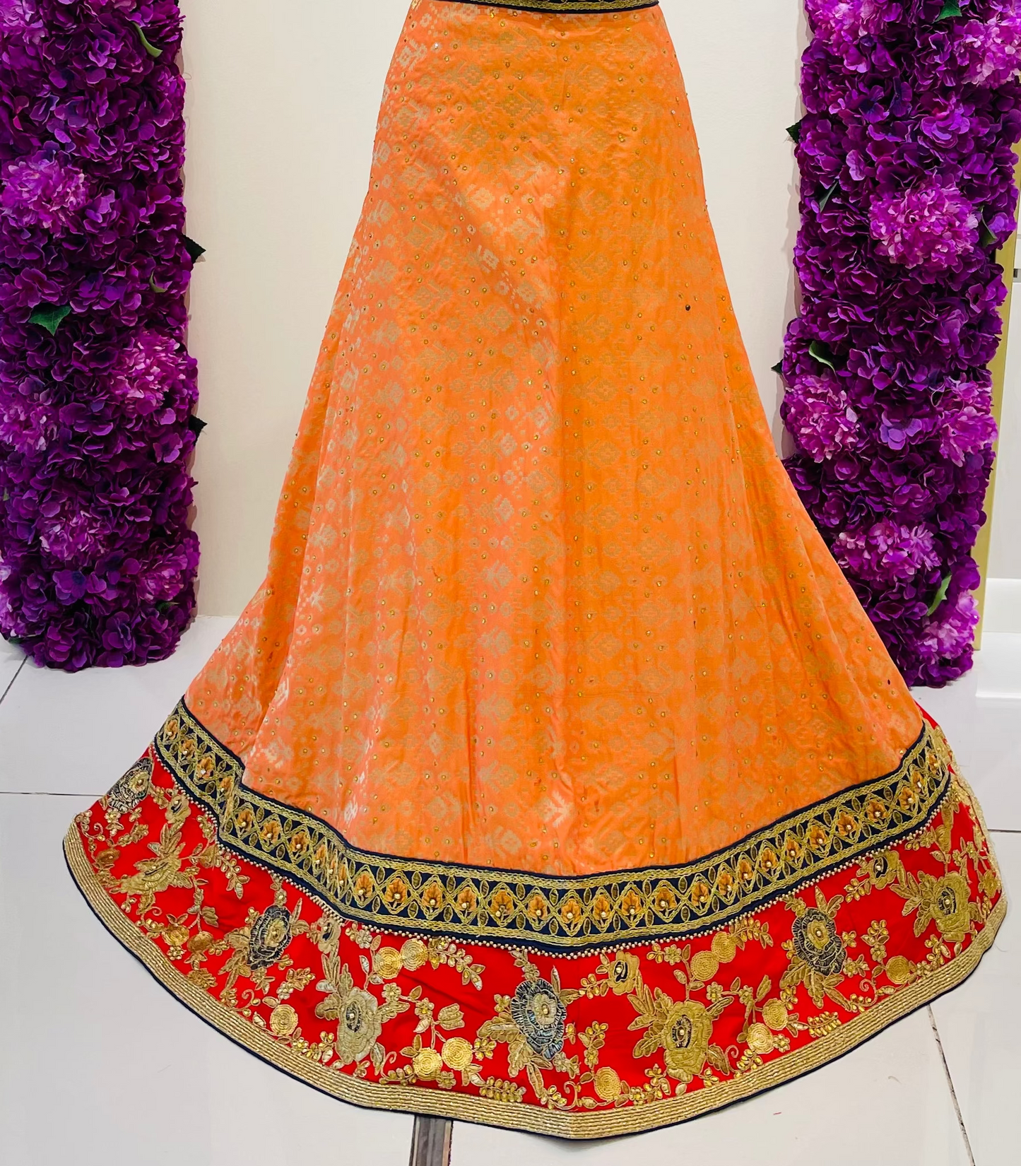 An orange and red embroidered traditional Indian lehenga skirt
