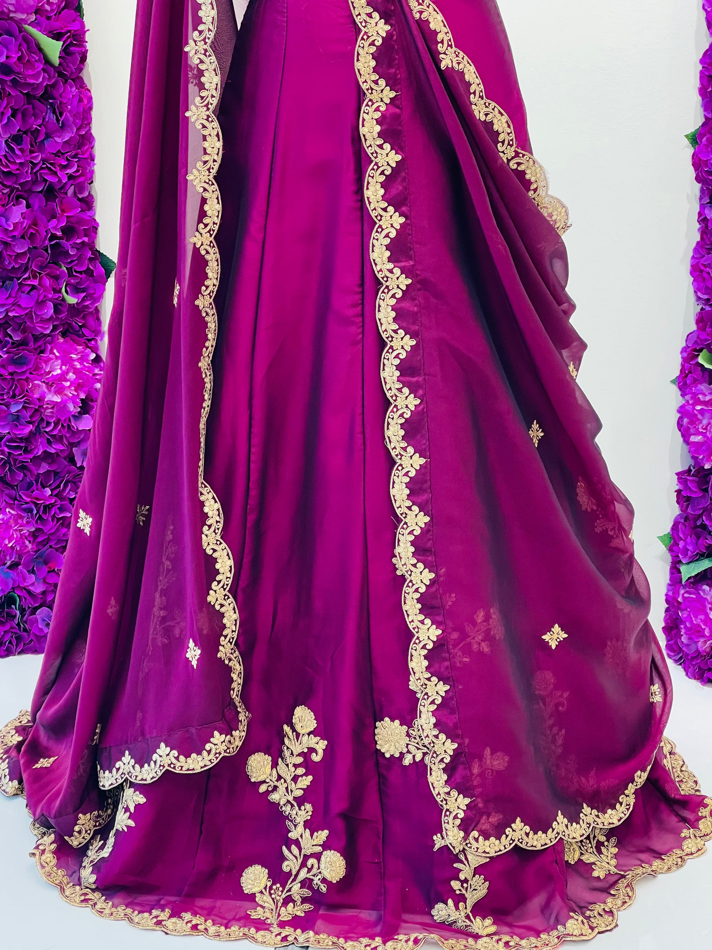 A magenta purple lehenga skirt with gold embroidered borders and floral motifs