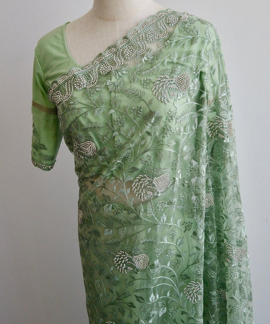 Green ready to wear Saree with embroidery and white stonework on a mannequin