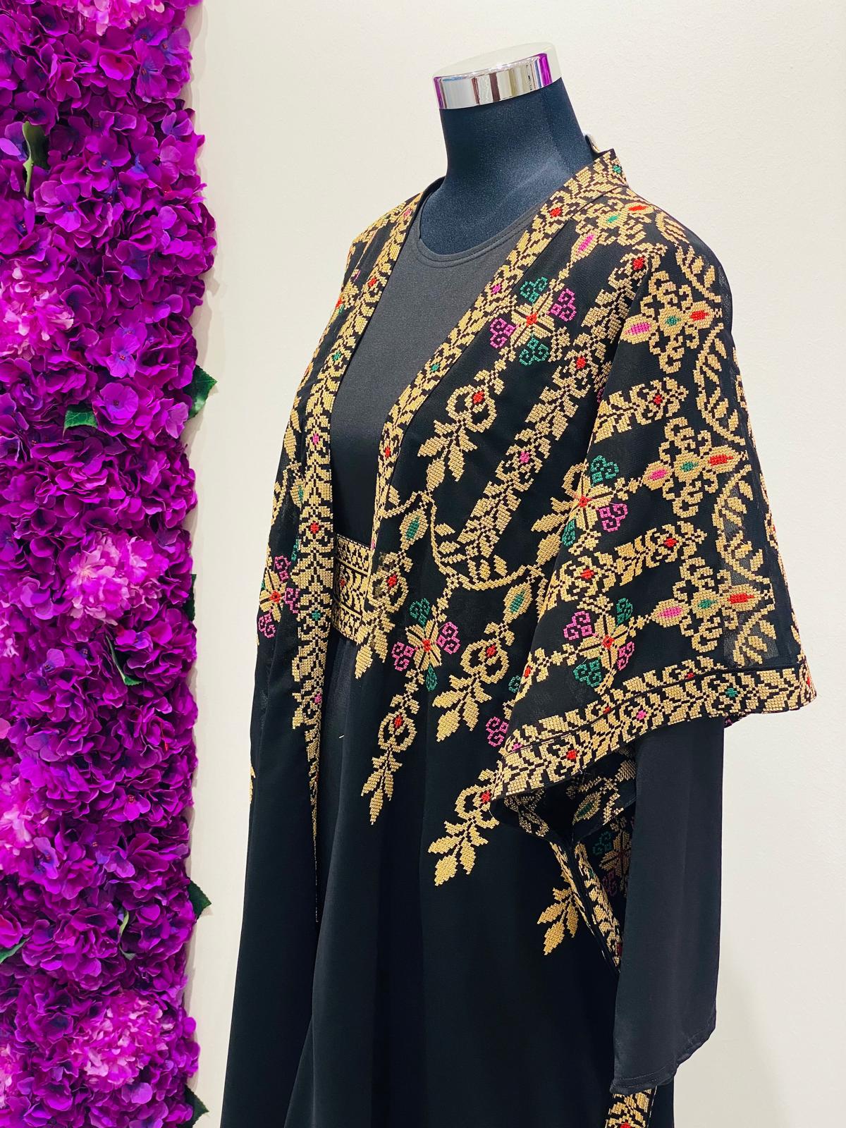 Luxury black Palestinian Thobe featuring royal gold Tatreez embroidery.