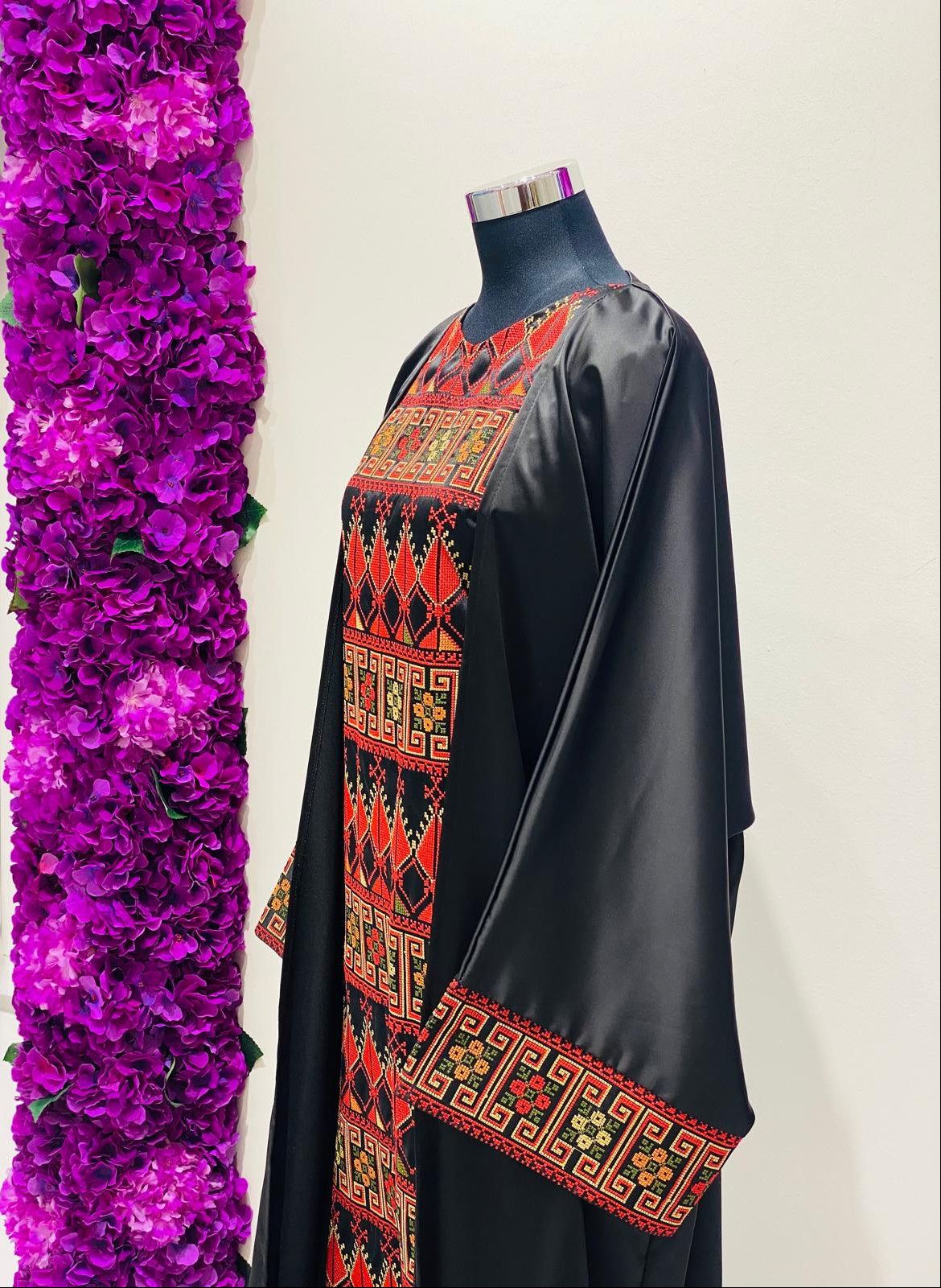Luxury black Palestinian thobe at Arisca Qatar, featuring bold red geometric embroidery.