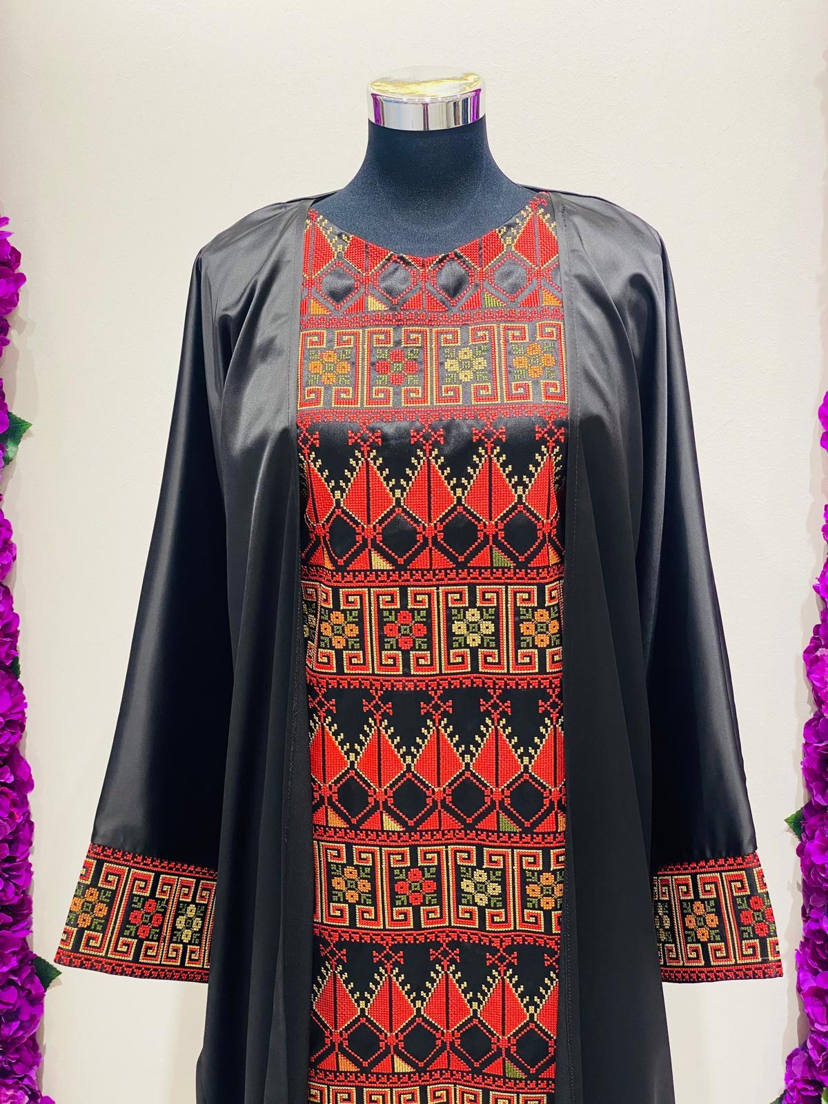 Luxury black Palestinian thobe at Arisca, featuring bold red geometric embroidery.