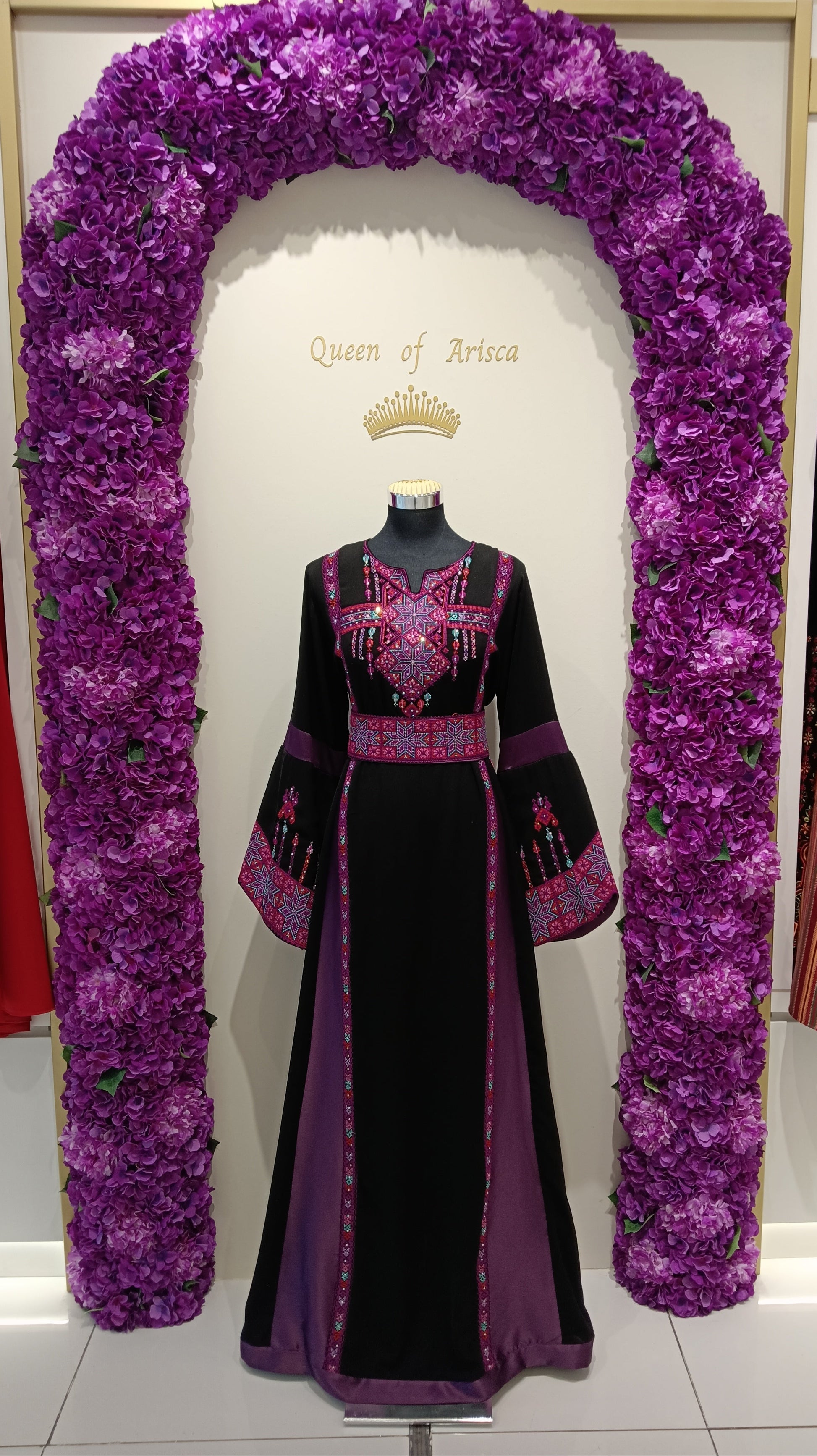 luxurious Palestinian thobe crafted from premium soft-flowing fabric in classic black, accented with rich purple panels and detailed pink-purple embroidery.