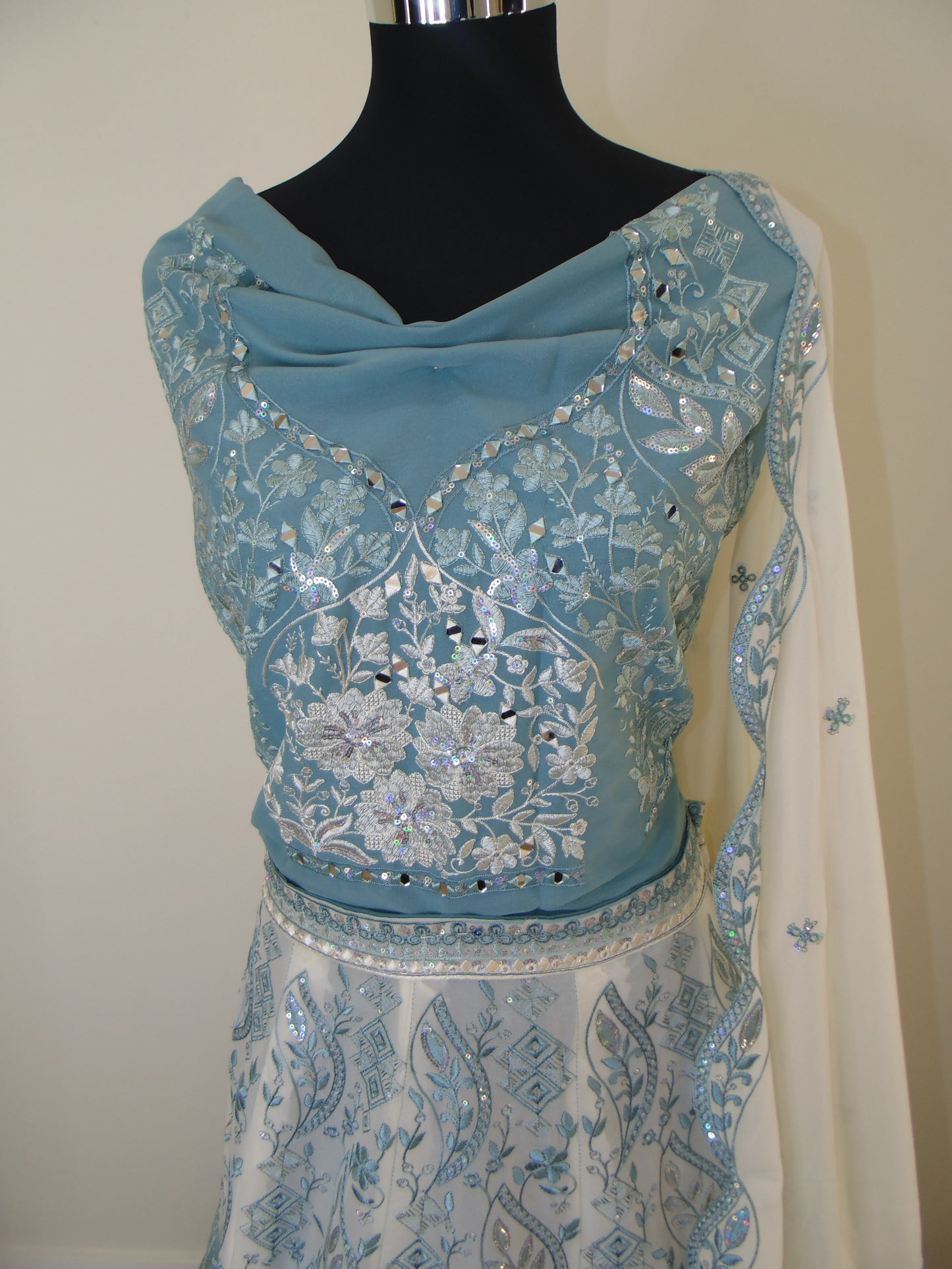 Blue embroidered lehenga on a mannequin with a plain background