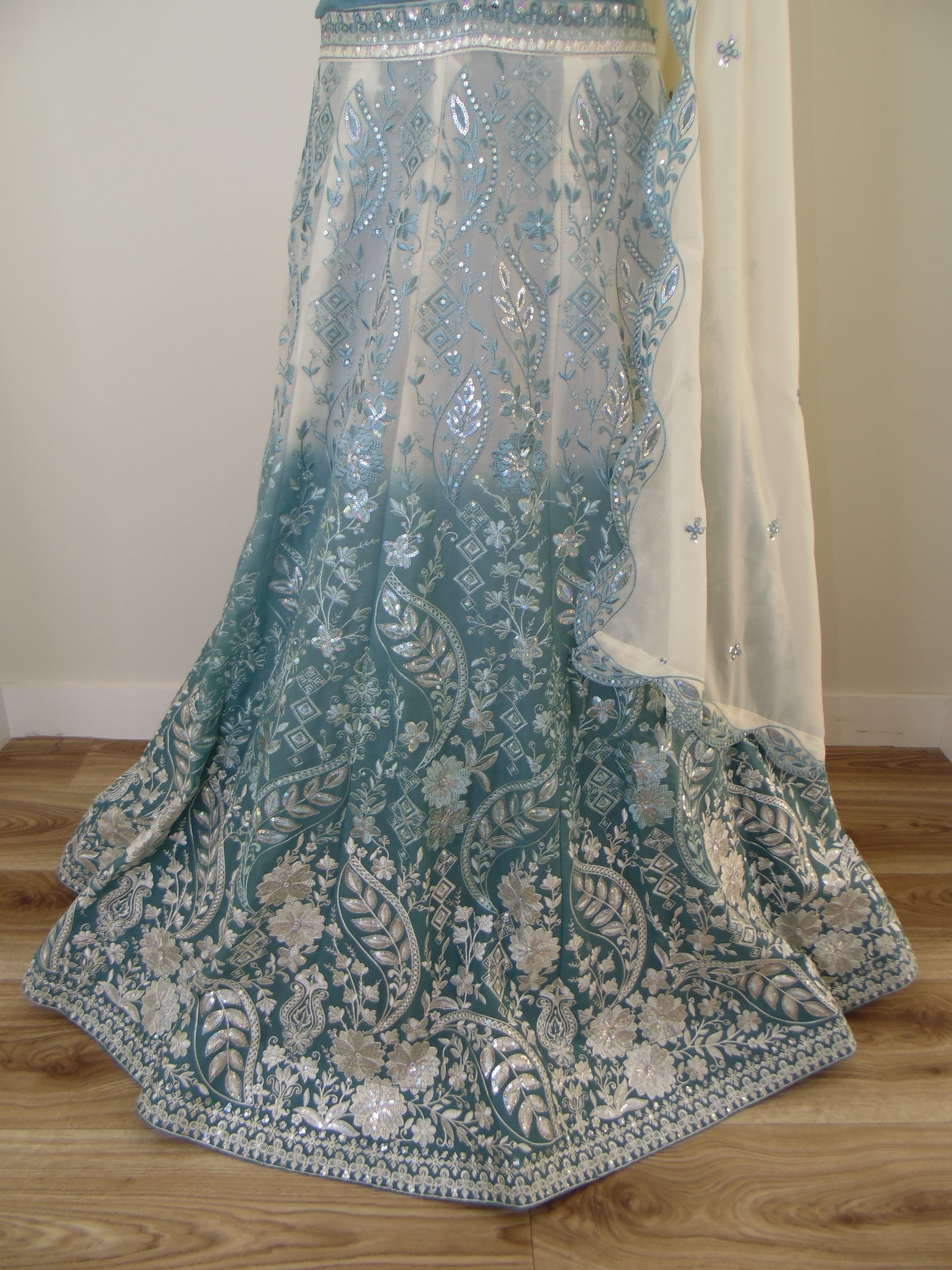 Embroidered lehenga with floral patterns on a wooden surface