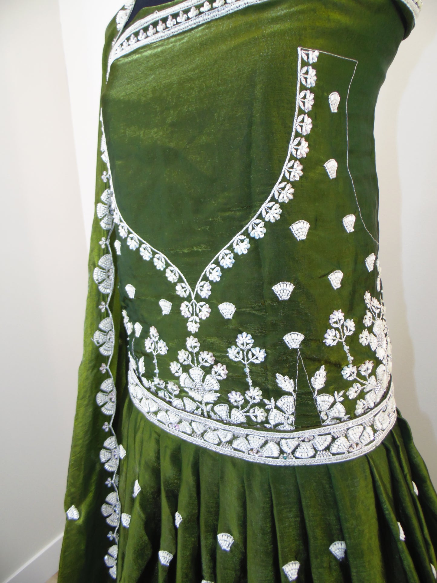 Green Indian Lehenga with white embroidery on a white background