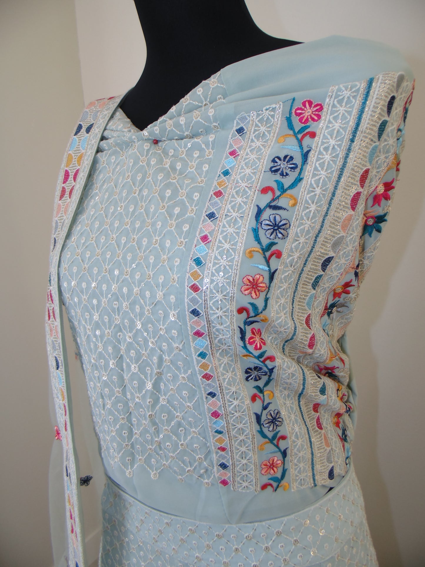 Embroidered fabric with colorful patterns on a plain background