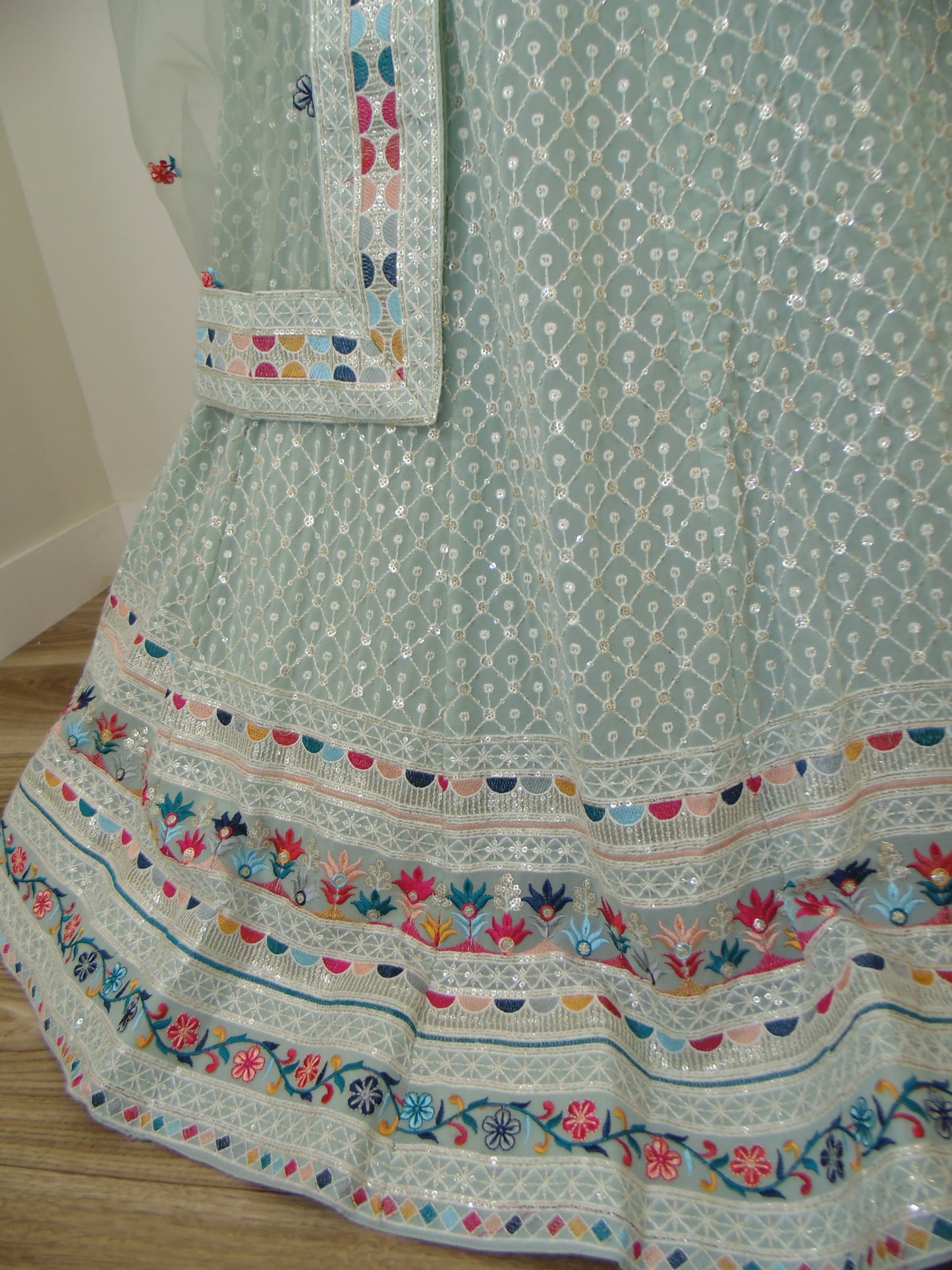 Embroidered fabric with colorful patterns on a light green background