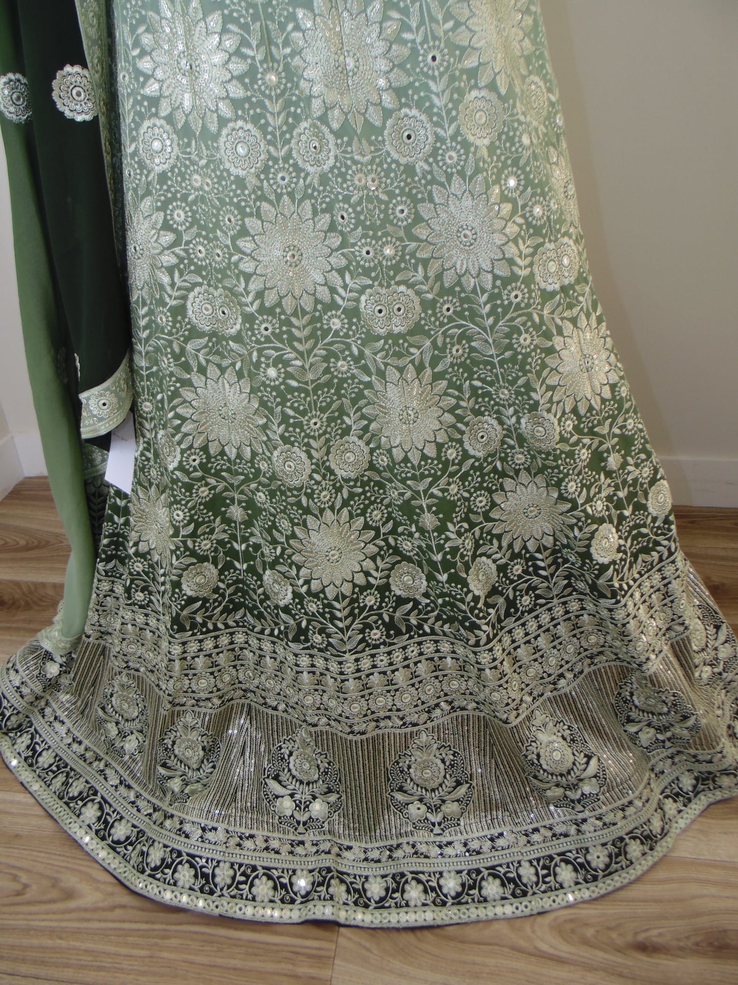 Green embroidered garment on a wooden surface