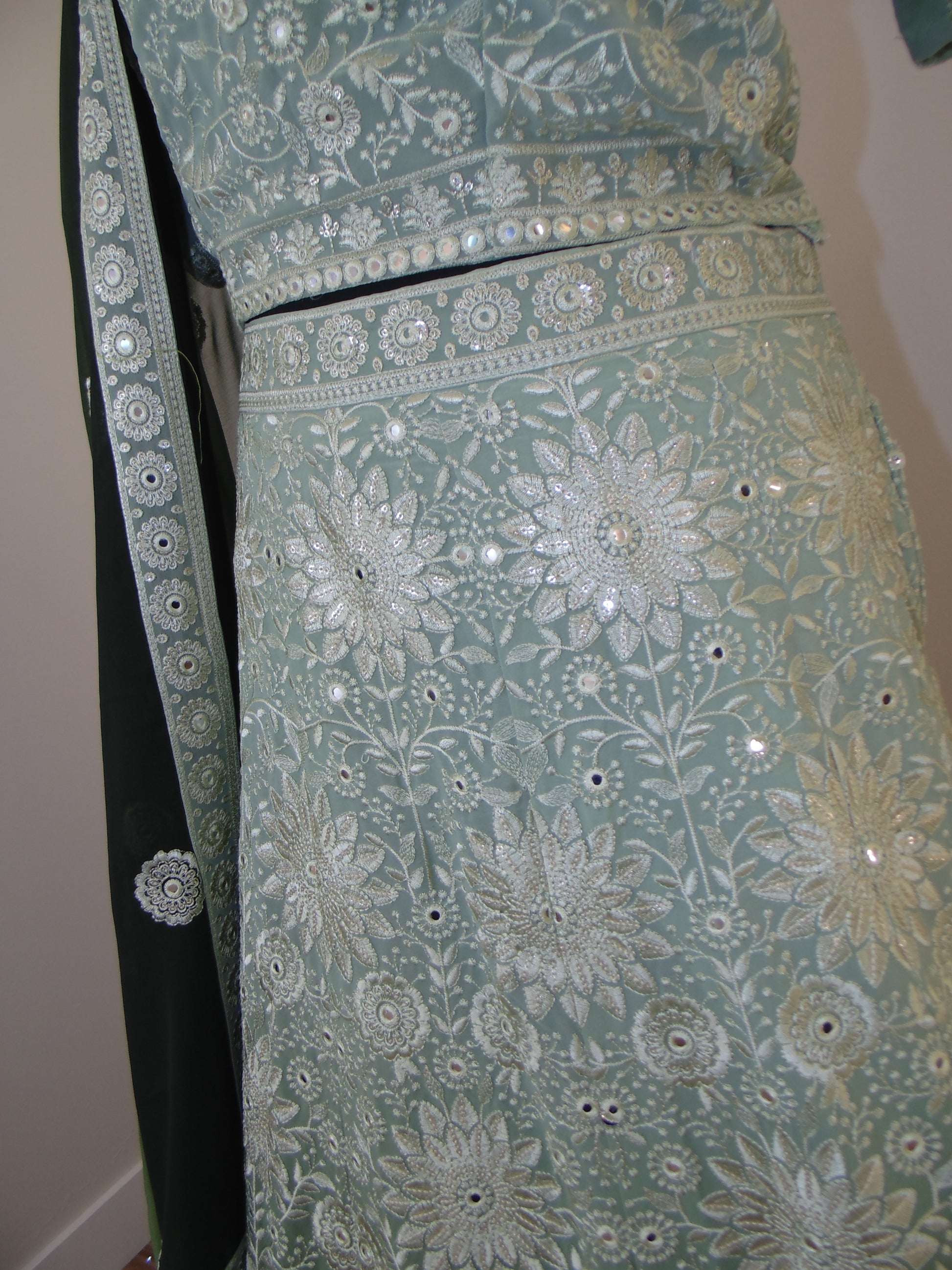 Decorative fabric with floral patterns and embellishments on a plain background