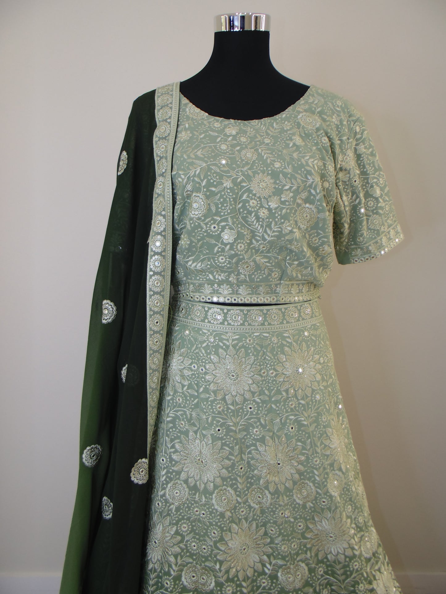 Green and black patterned Lehenga on a white background