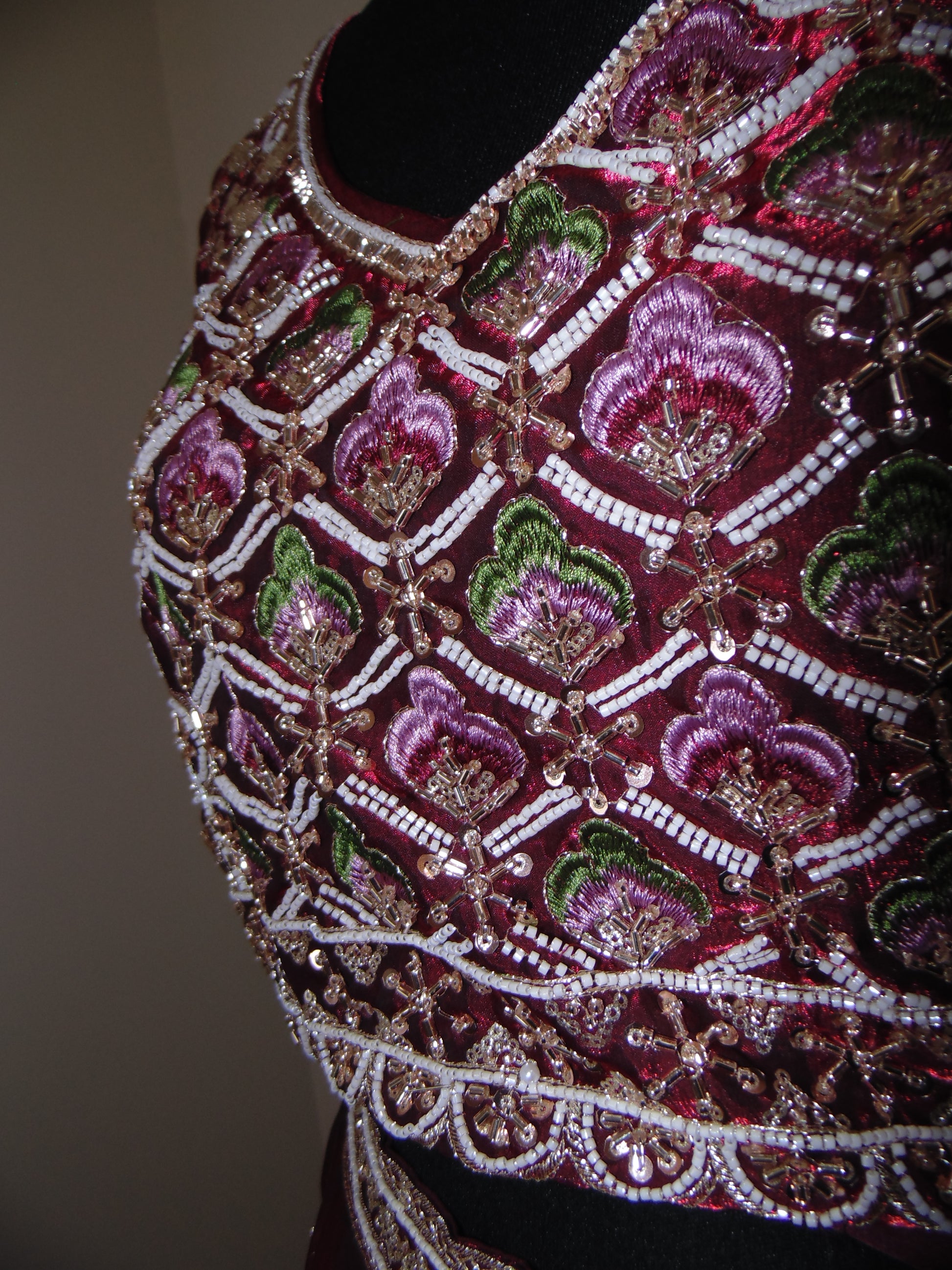 Close-up of a intricately embroidered garment with floral patterns on a plain background