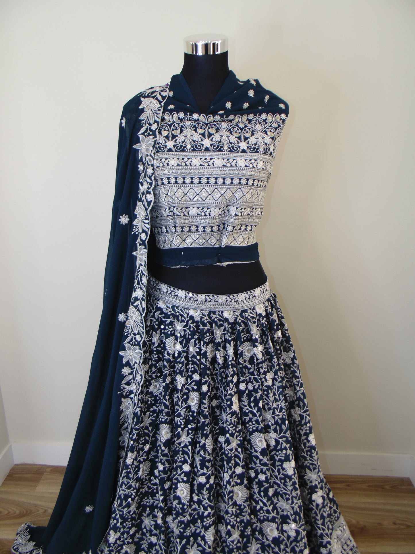 Navy blue dress with white floral patterns on a mannequin against a plain background