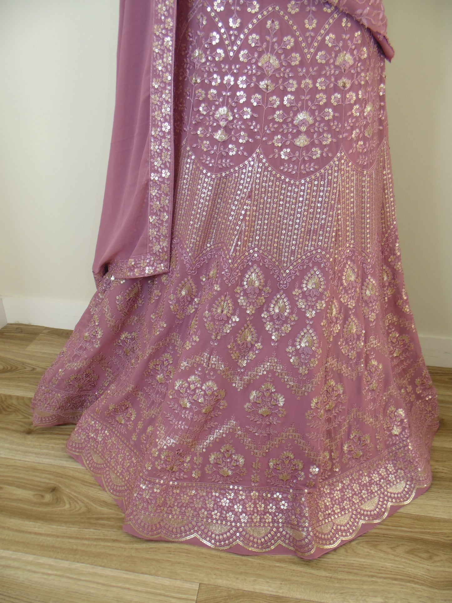 Pink embroidered fabric on a wooden surface