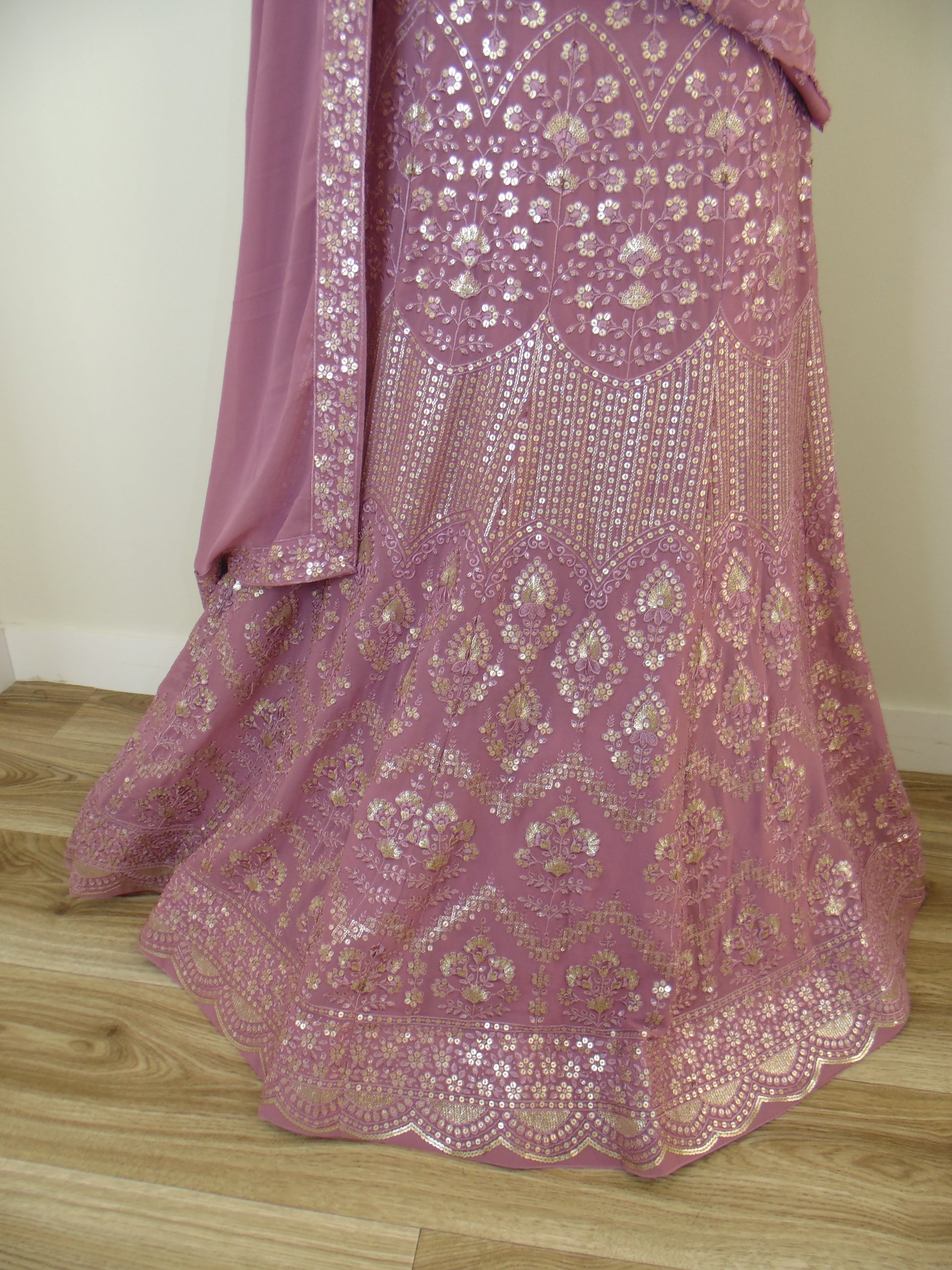 Pink embroidered fabric on a wooden surface