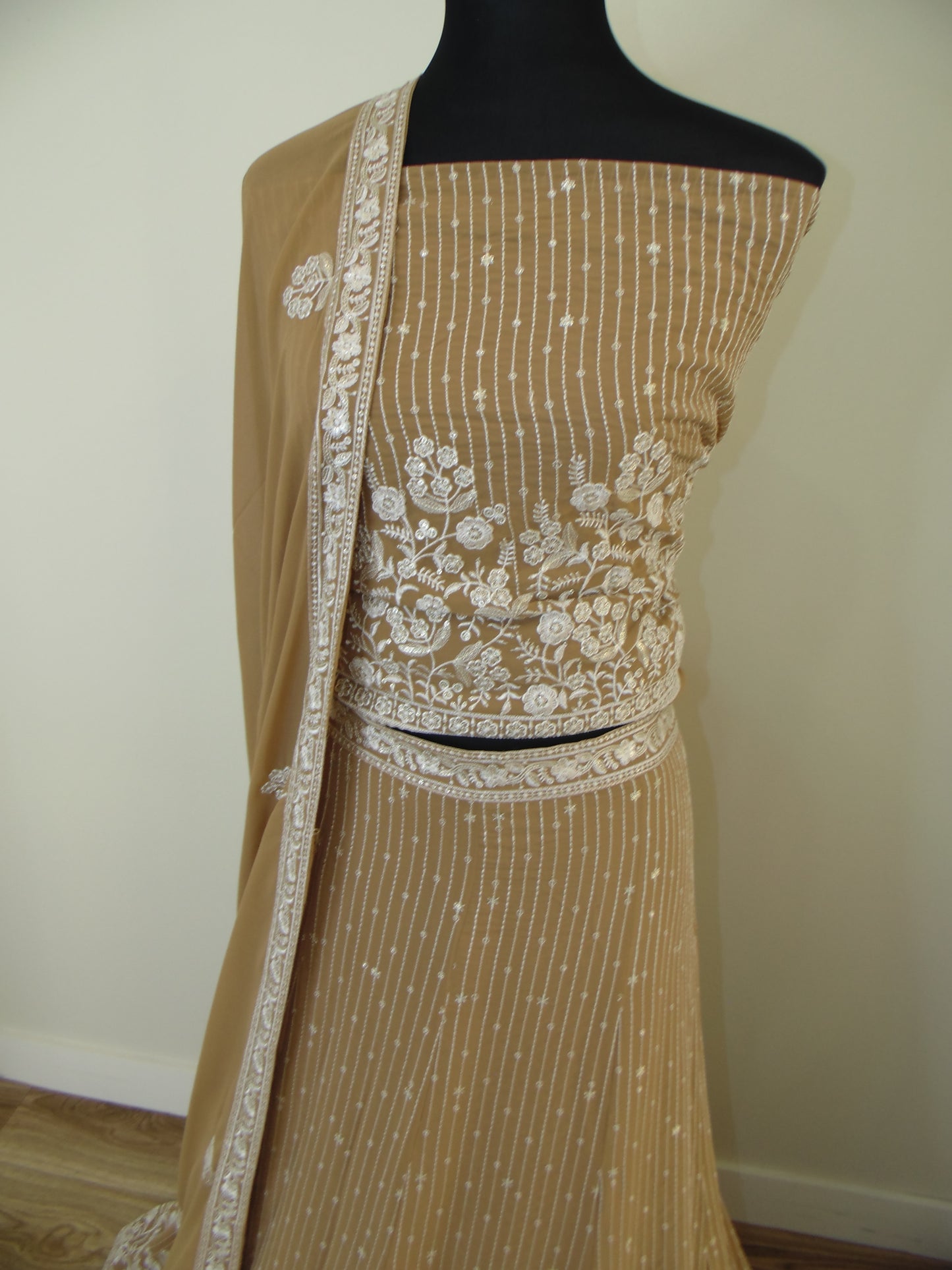 Brown fabric with white lace detailing on a plain background