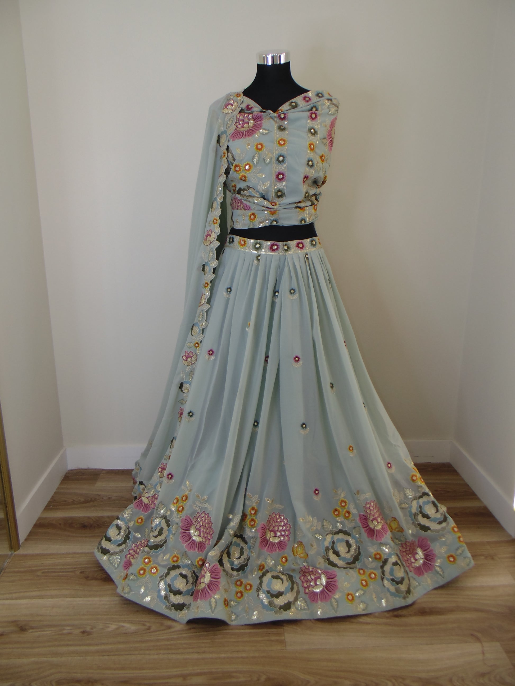 Floral embroidery Indian Lehenga with zari patterns on a plain wall
