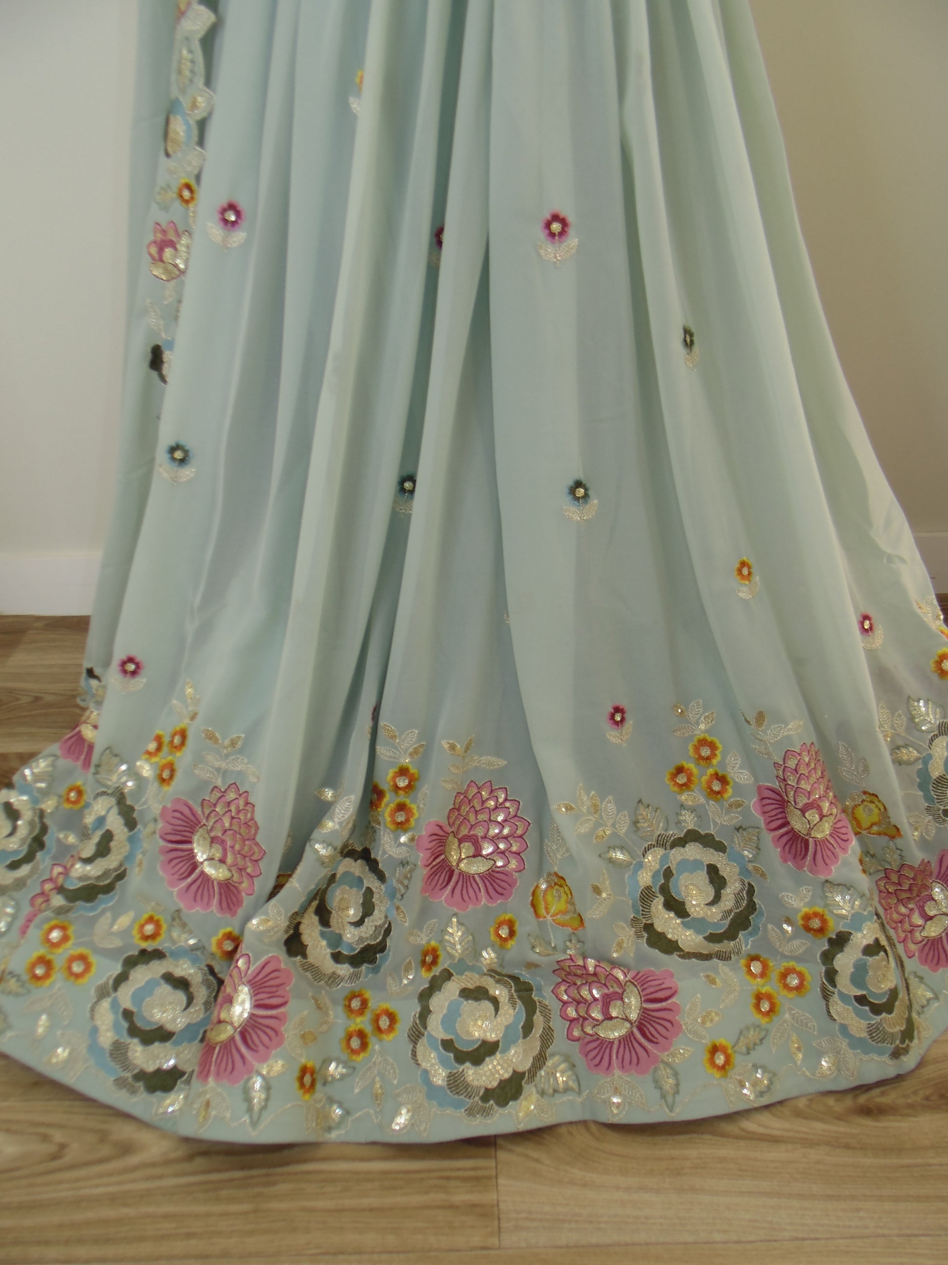 Light blue fabric with floral embroidery on a wooden surface