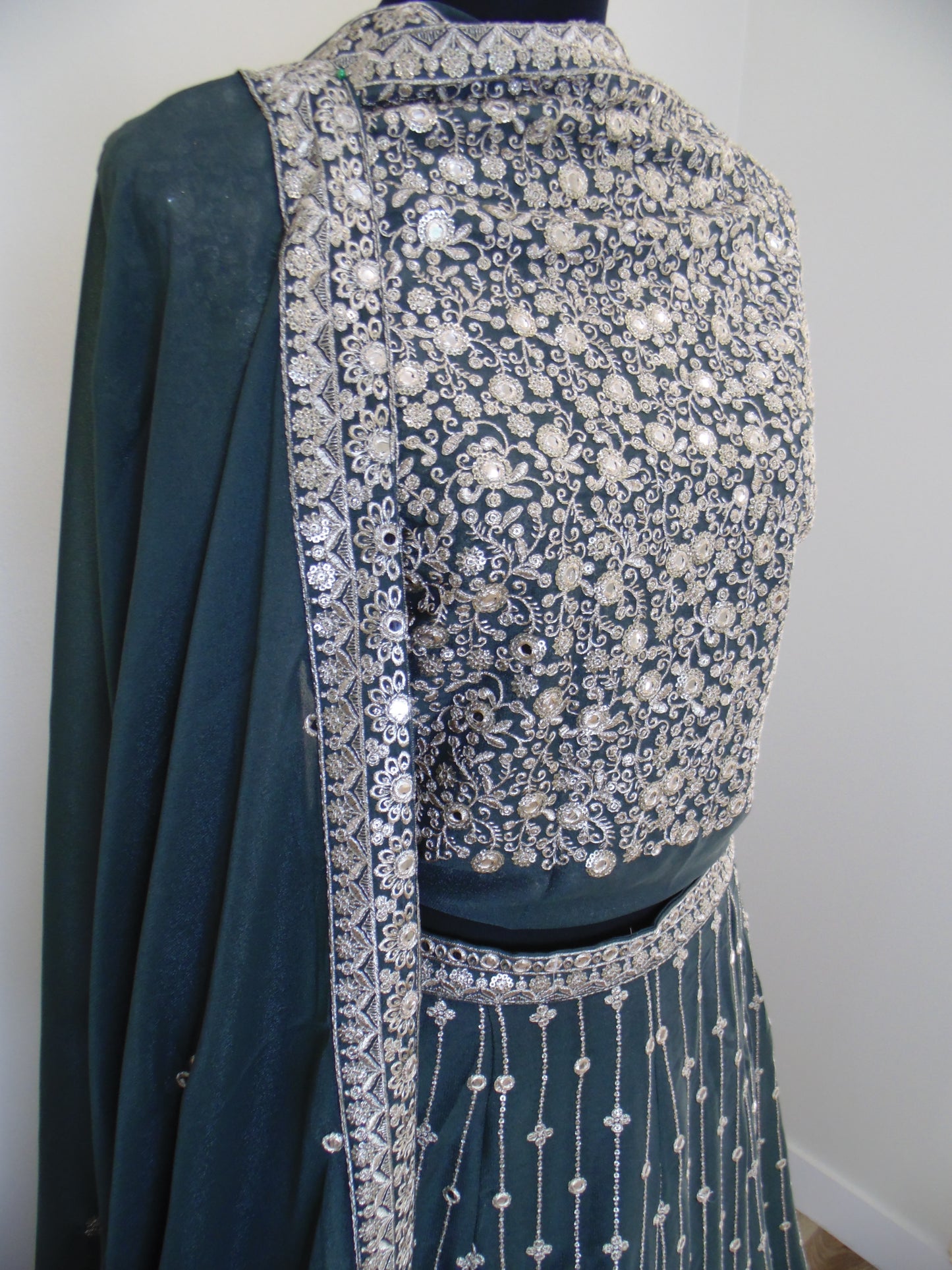 Green fabric with silver embellishments on a white background