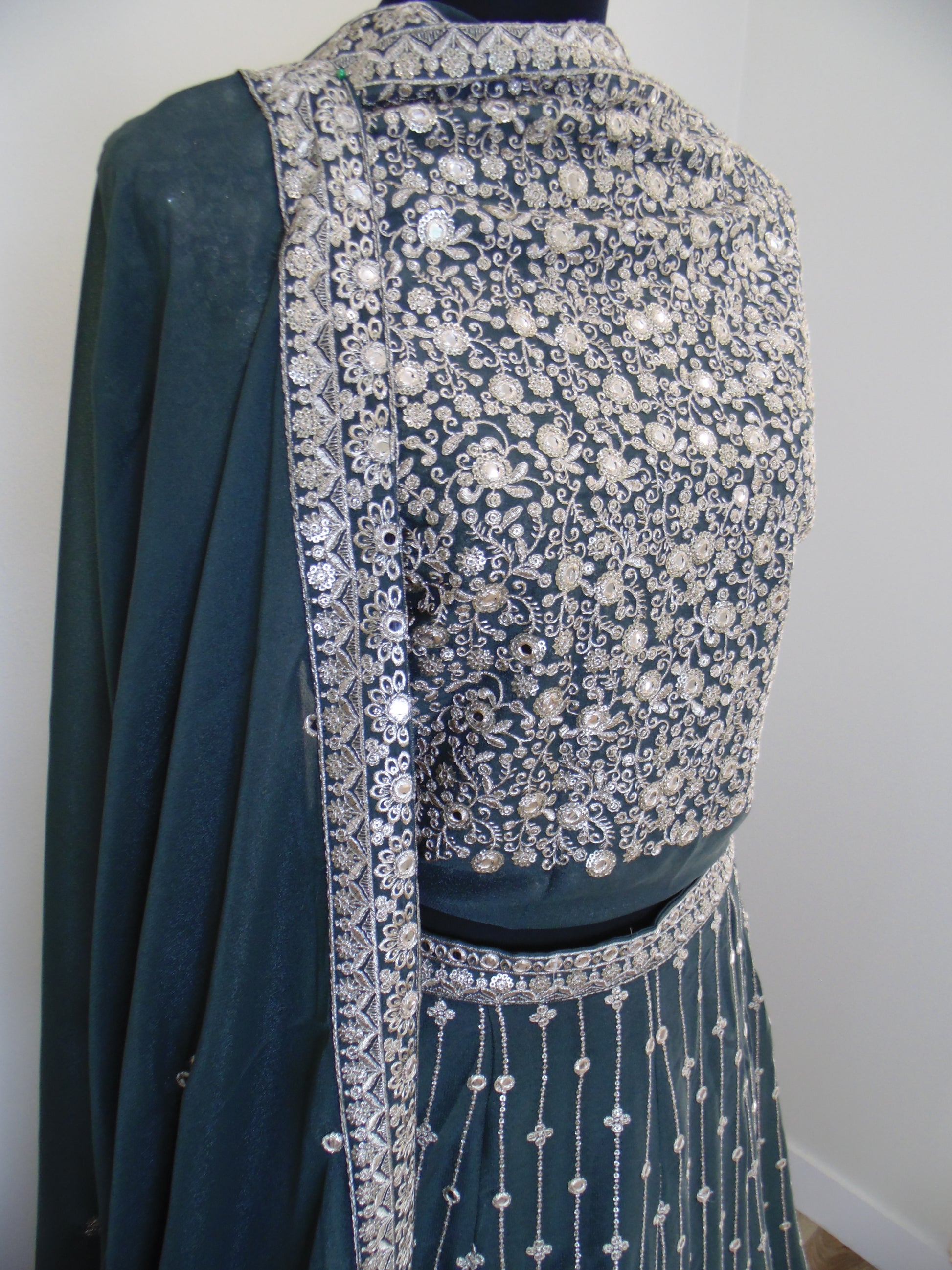 Green fabric with silver embellishments on a white background