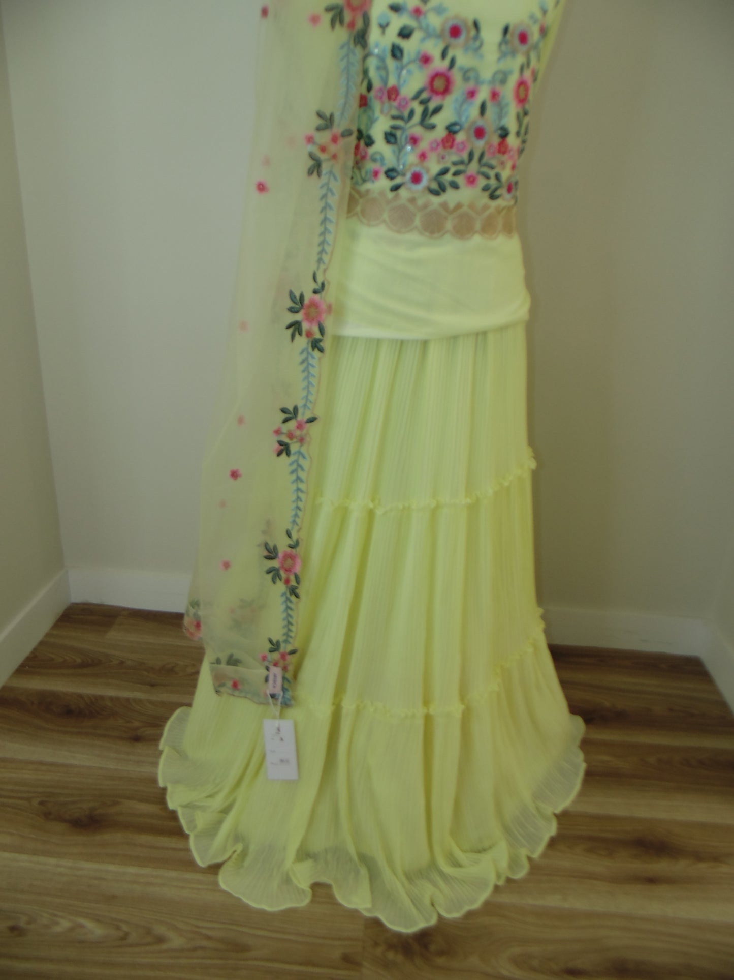 Light yellow dress with floral embroidery on a white background