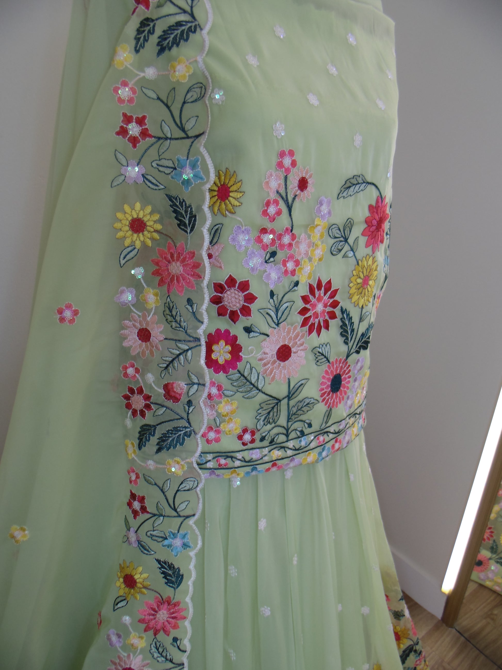 Light green fabric with floral embroidery on a white background