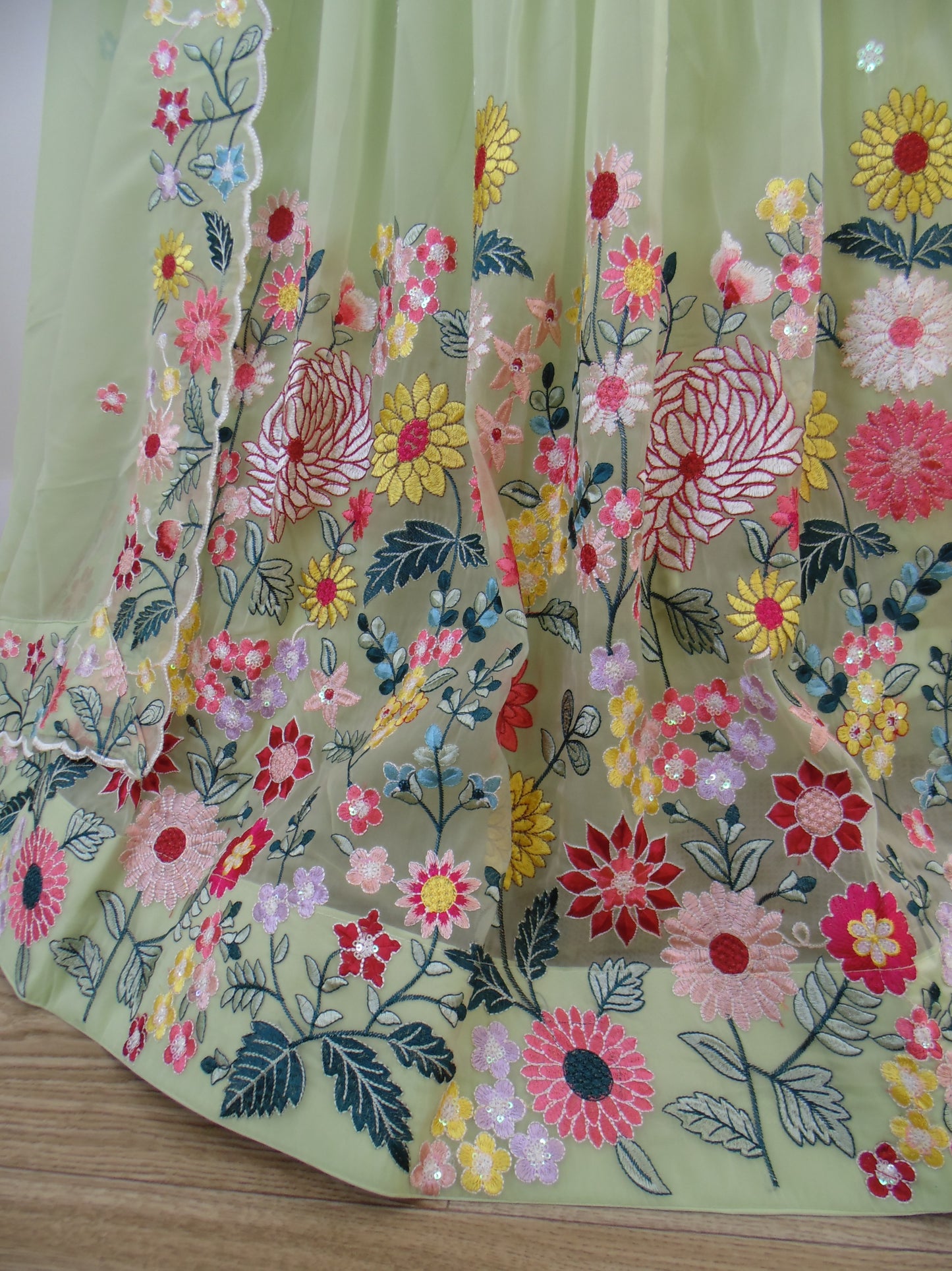 Embroidered fabric with colorful floral patterns on a wooden surface