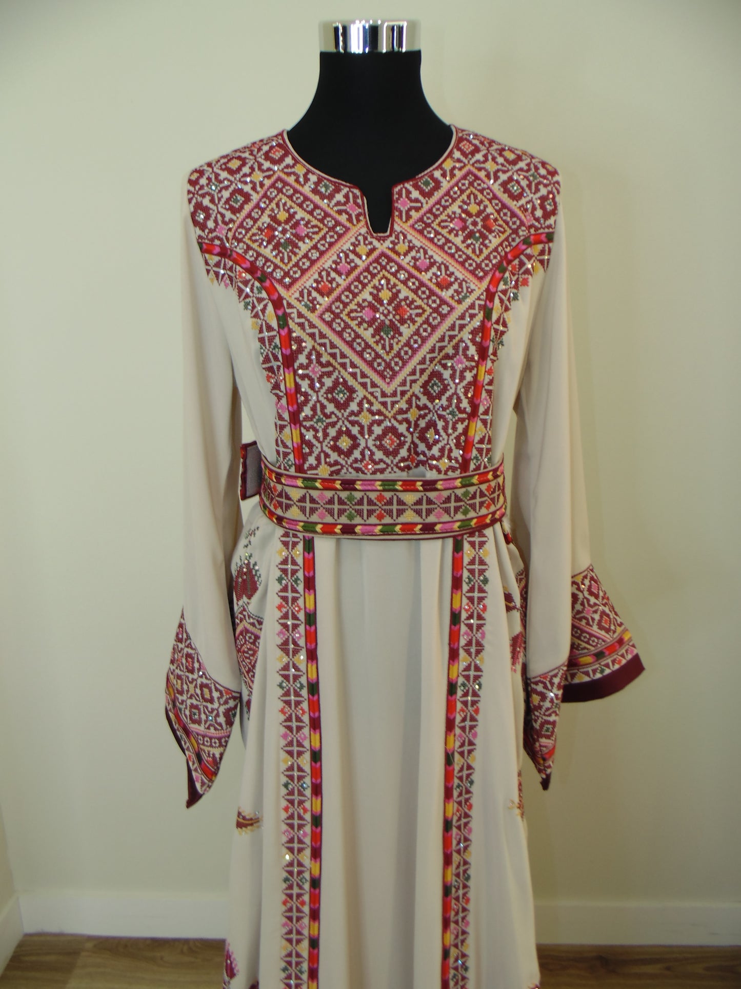 Traditional embroidered garment on a mannequin against a plain background