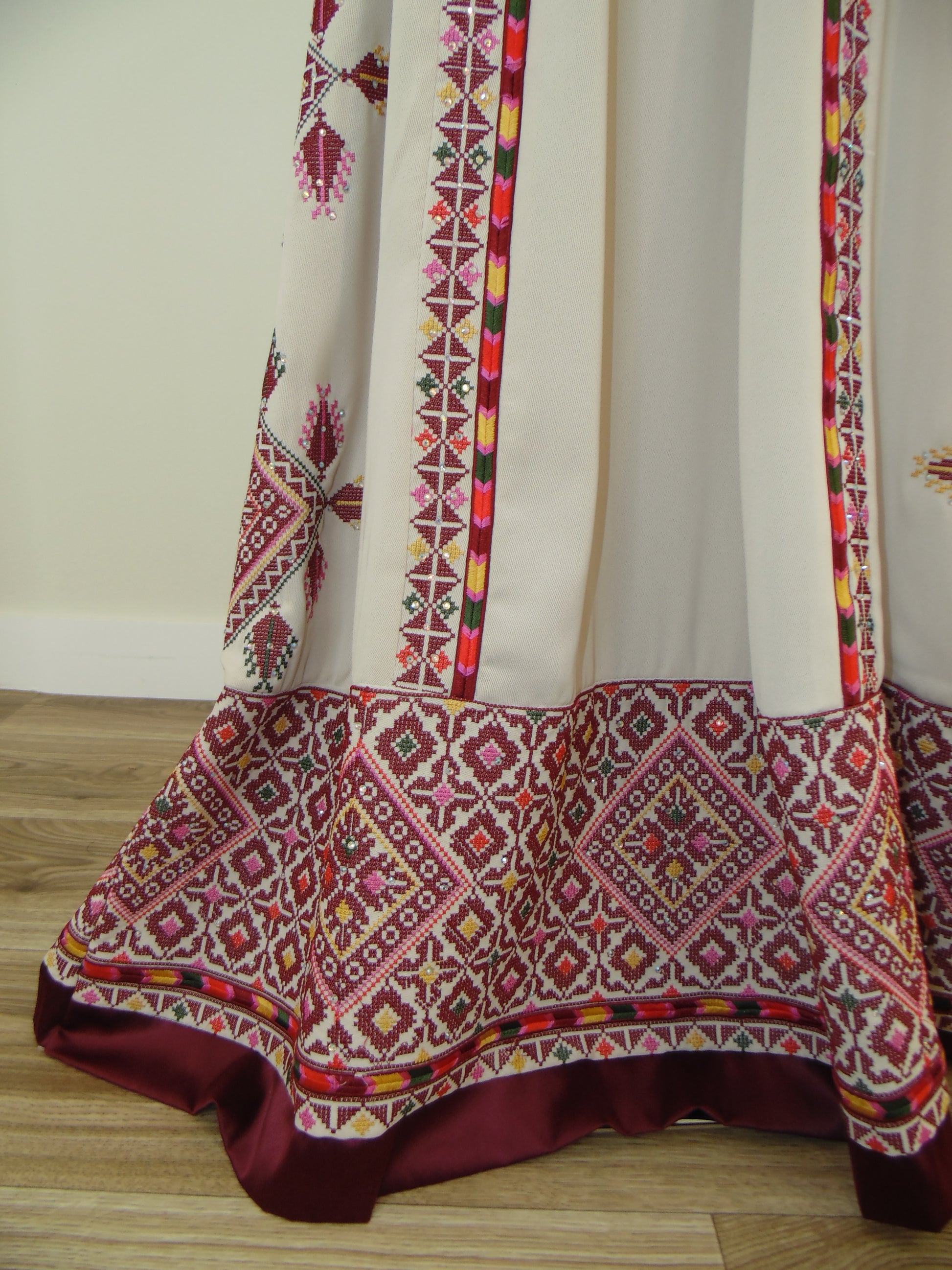 Traditional embroidered fabric with geometric patterns on a white background
