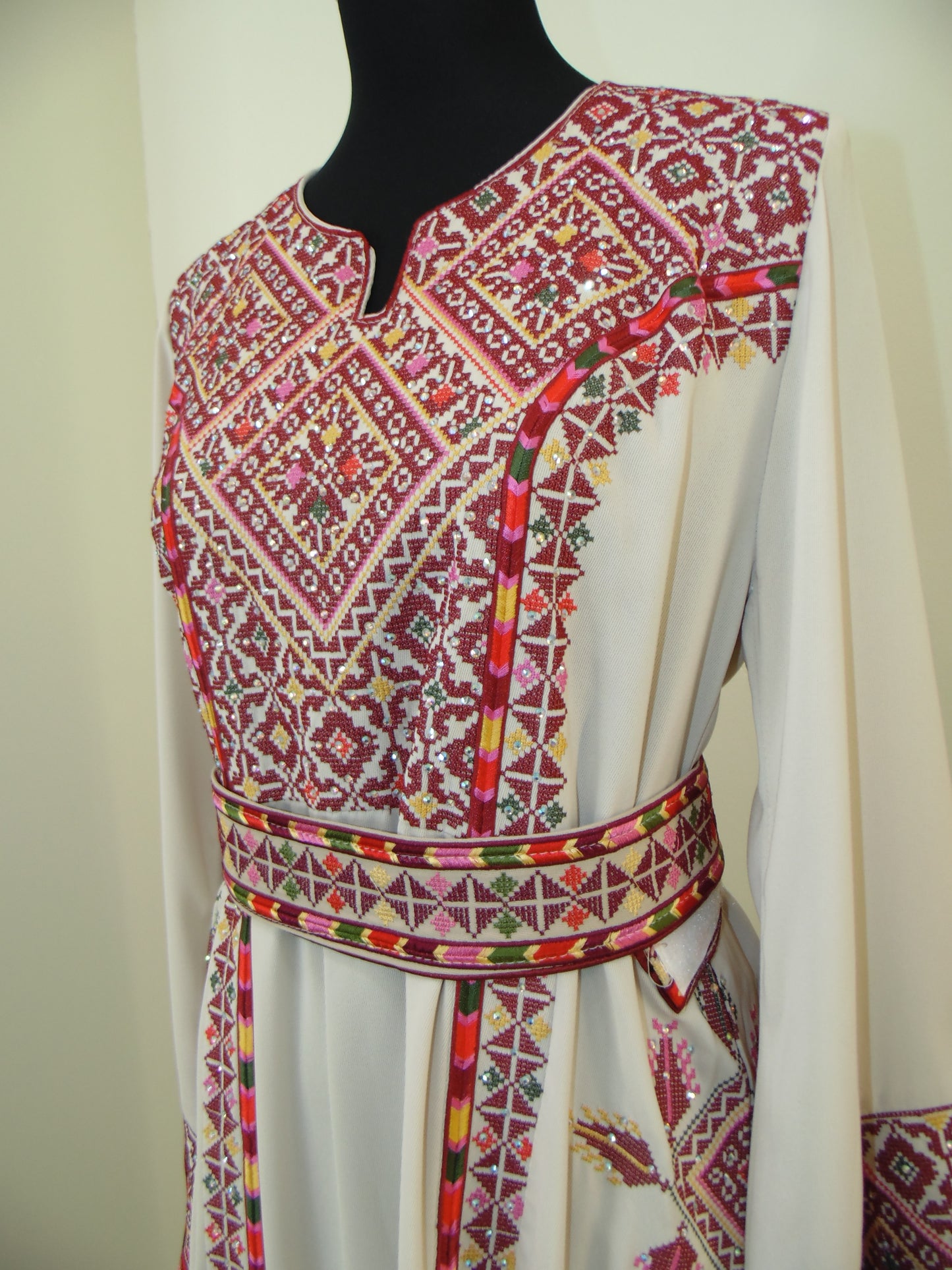 Traditional embroidered garment with intricate patterns on a white background