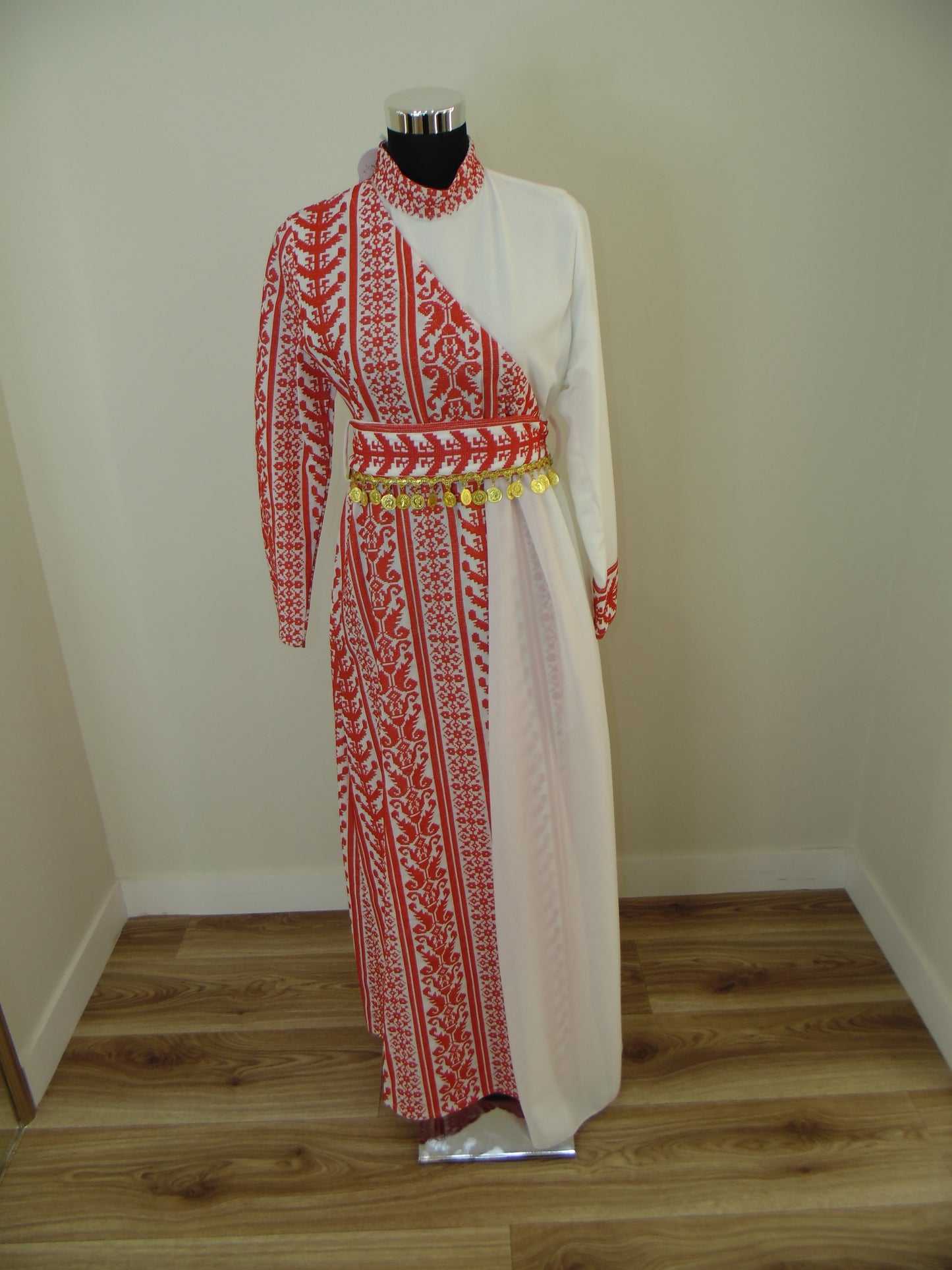 Traditional embroidered Palestinian Thobe on a mannequin against a white wall