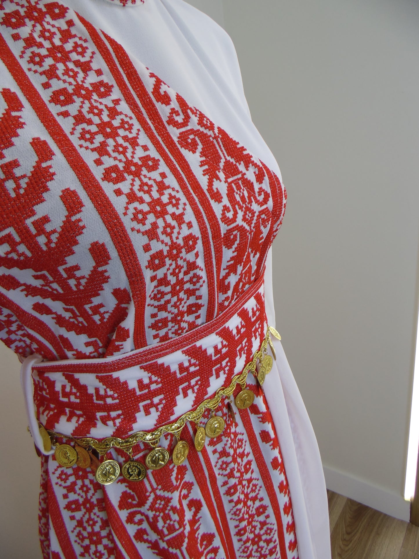 Embroidered fabric with red and white pattern on a plain background