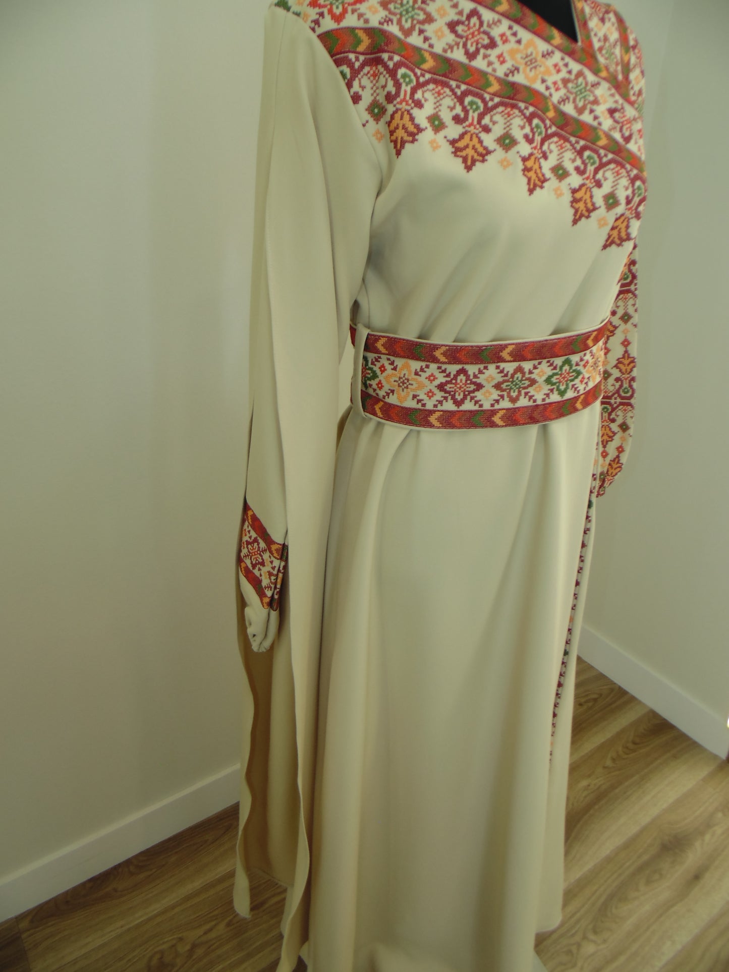 Traditional embroidered Palestinian Thobe on a mannequin against a plain background