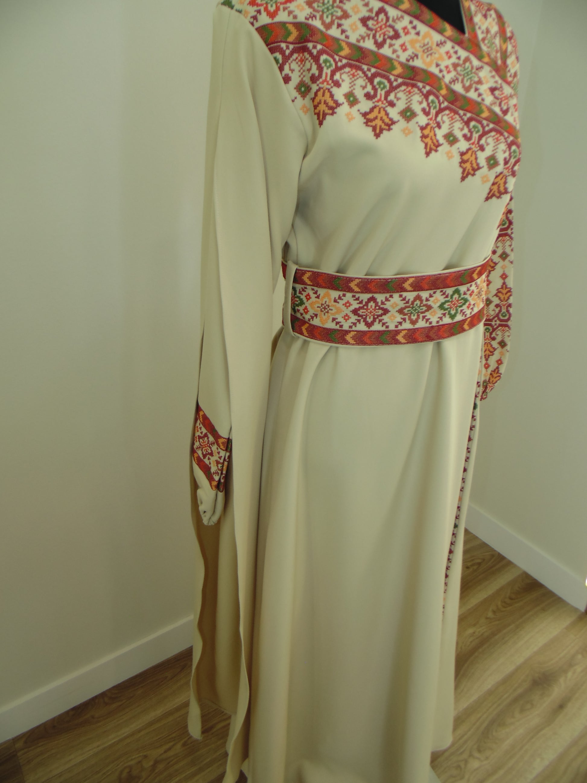 Traditional embroidered Palestinian Thobe on a mannequin against a plain background