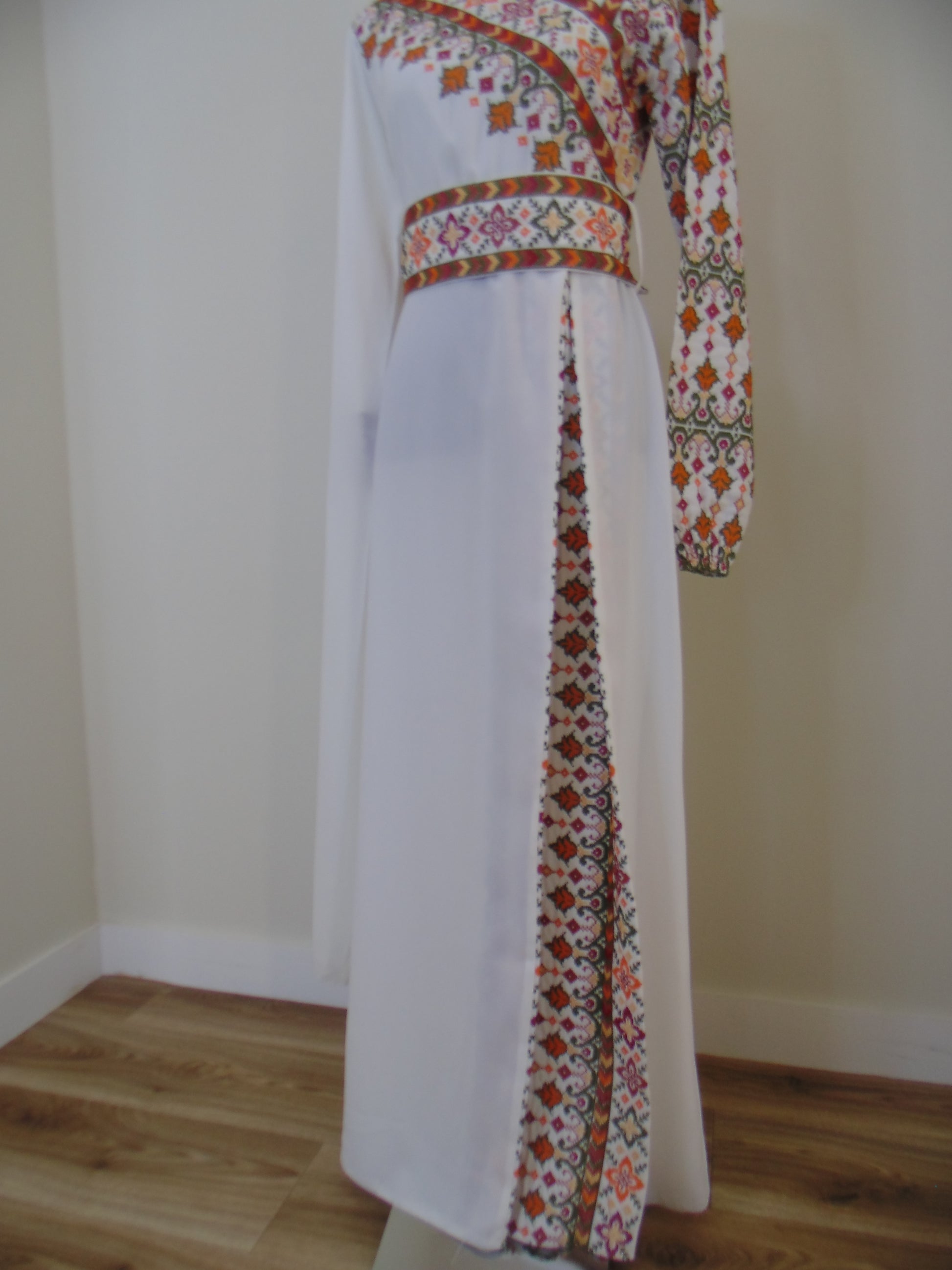 Palestinian Thobe with floral patterns on a white surface